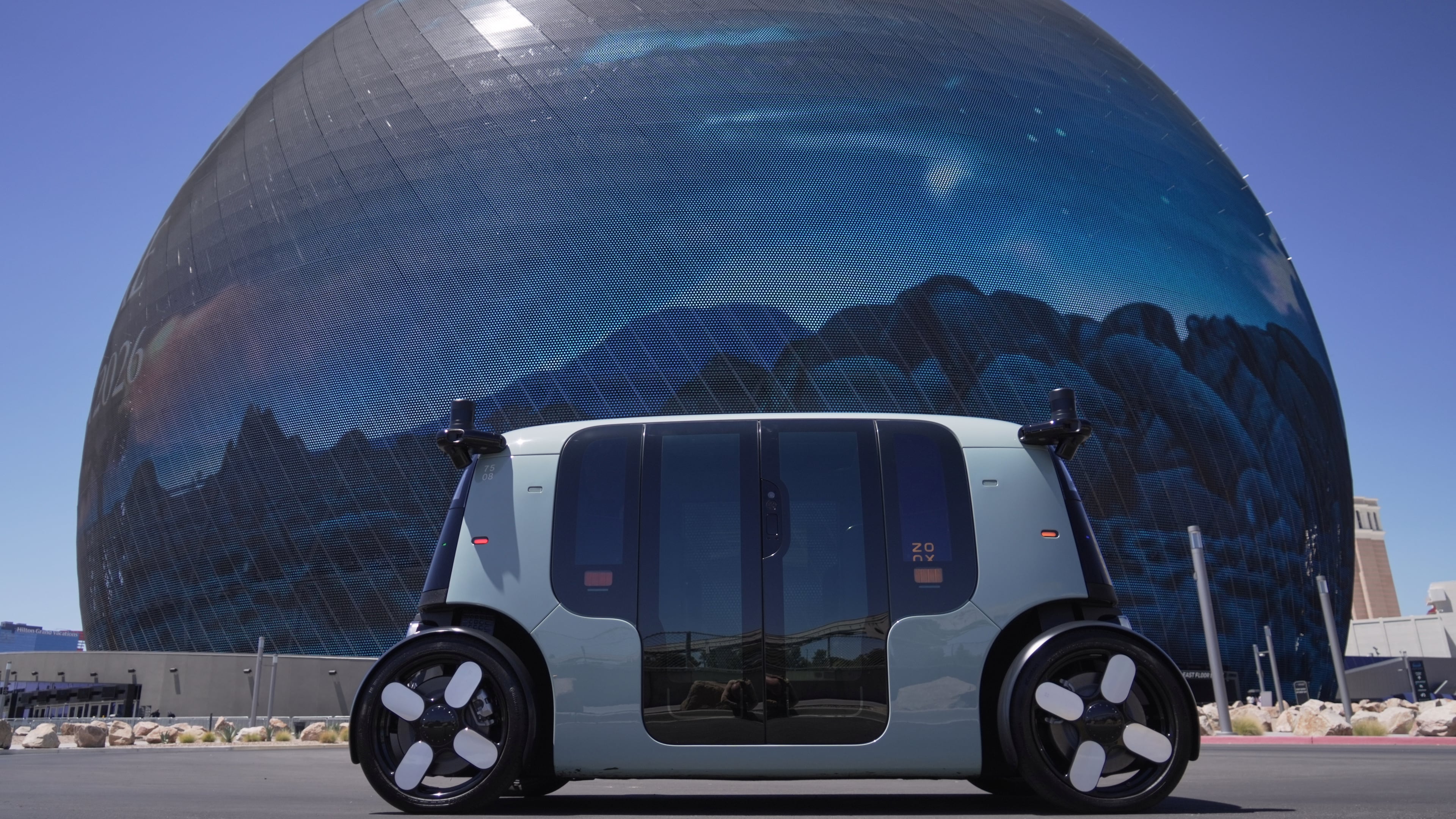An Amazon Zoox taxi with no steering wheel drives in front of The Sphere on the Las Vegas strip, Thursday, July 30, 2026. (AP Photo/Ty ONeil)