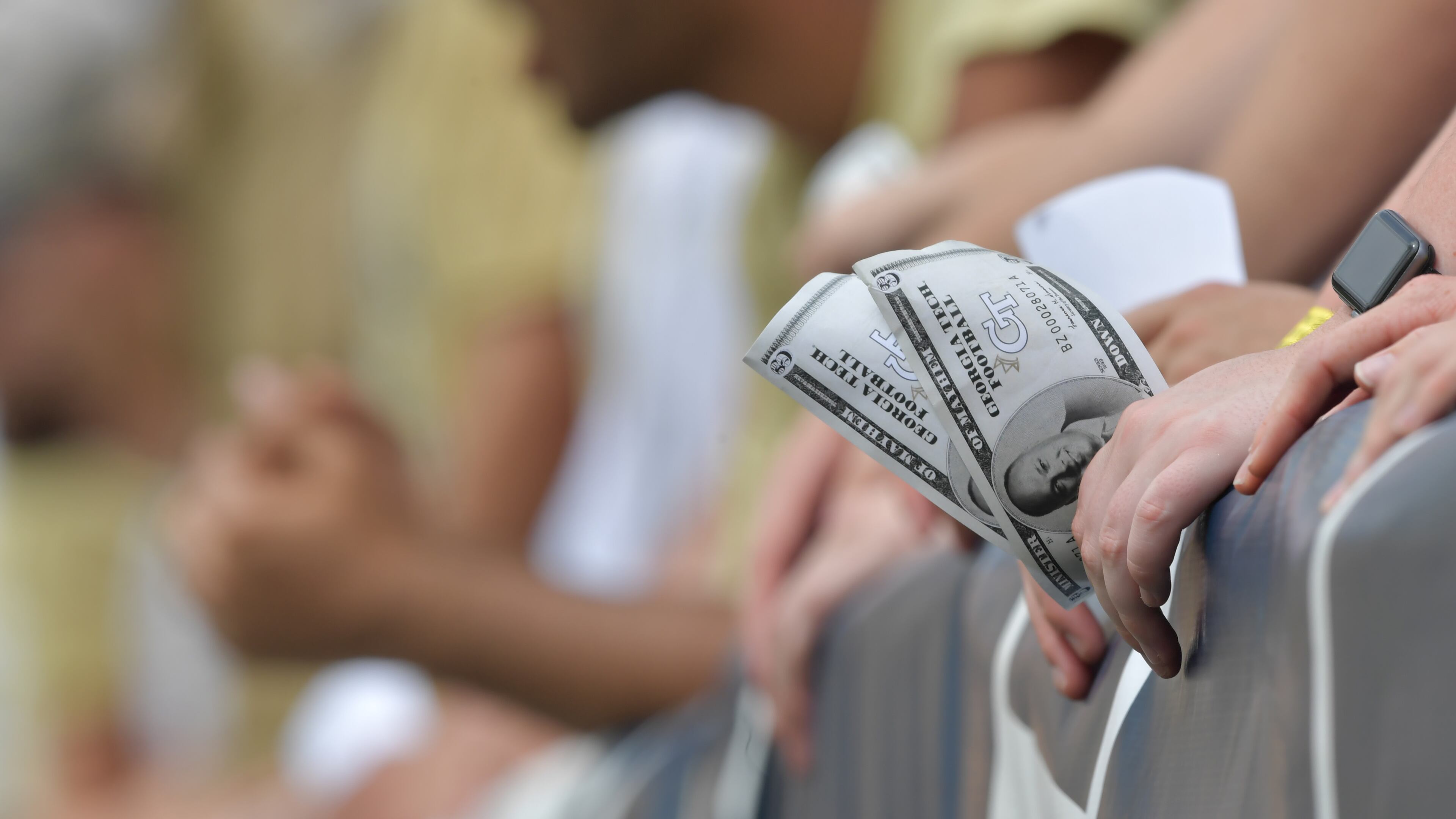 A Georgia Tech fan holds fake money printed with the portrait of Georgia Tech head coach Geoff Collins in the first half at Bobby Dodd Stadium on Saturday, Sept. 14, 2019.