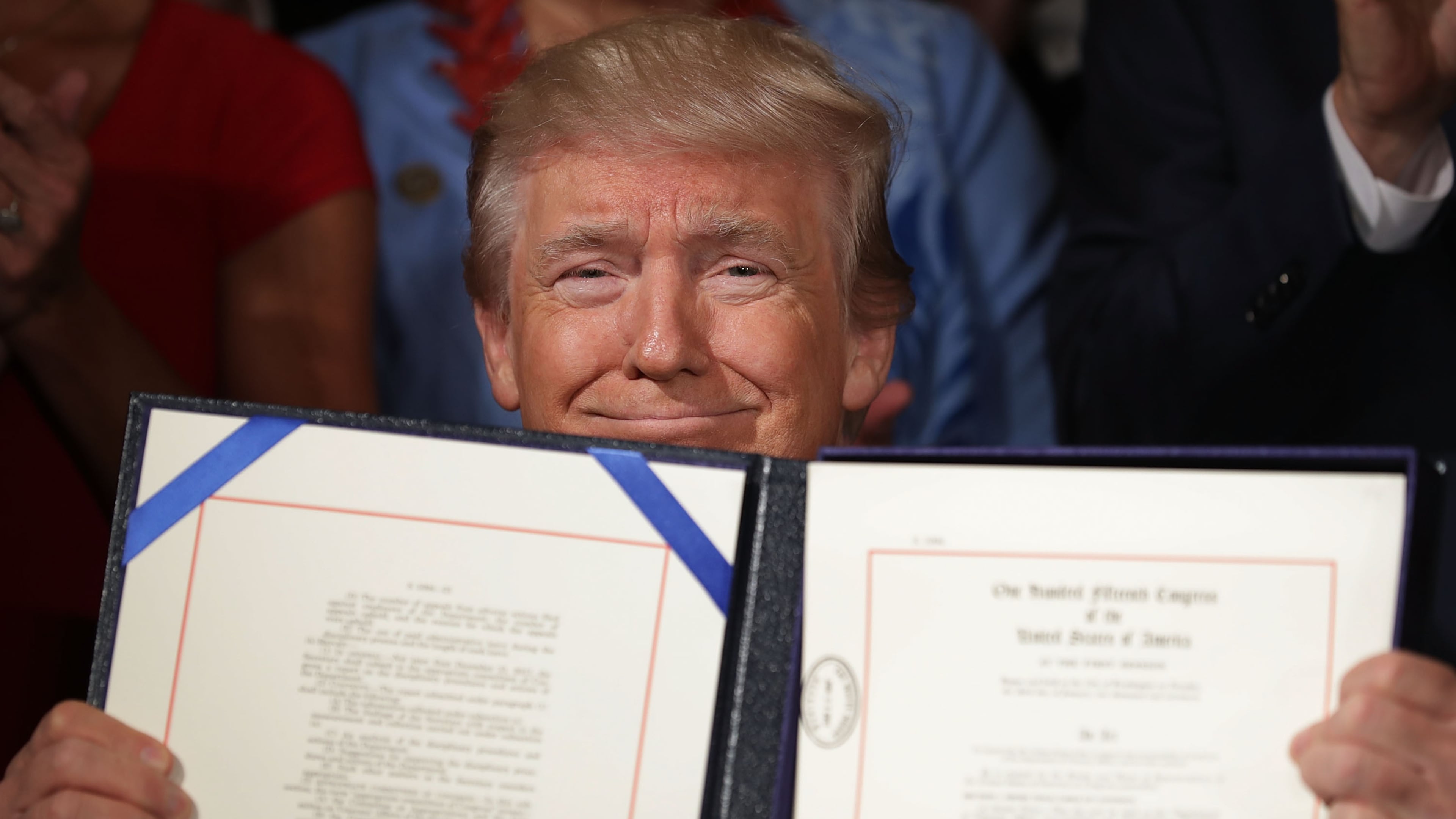 President Donald Trump holds up the Department of Veterans Affairs Accountability and Whistleblower Protection Act of 2017 after signing it Friday during a ceremony in the East Room of the White House. (Photo by Chip Somodevilla/Getty Images)