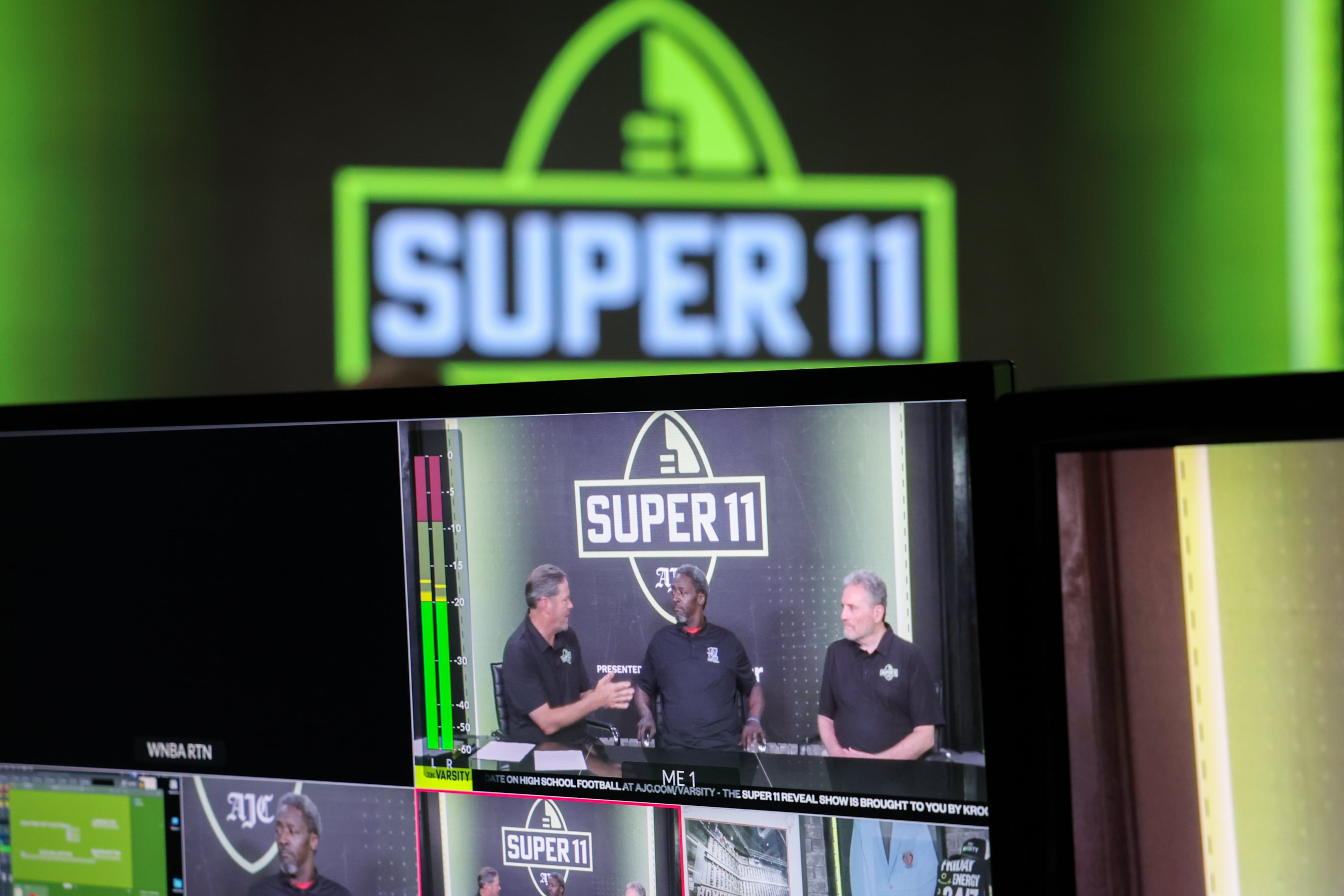 DawgNation’s Brandon Adams appears with former Super 11 honoree Quincy Carter and AJC’s Todd Holcomb during the taping of the Super 11 reveal show at Score ATL in Roswell on Aug. 3, 2026. (Arvin Temkar/AJC)