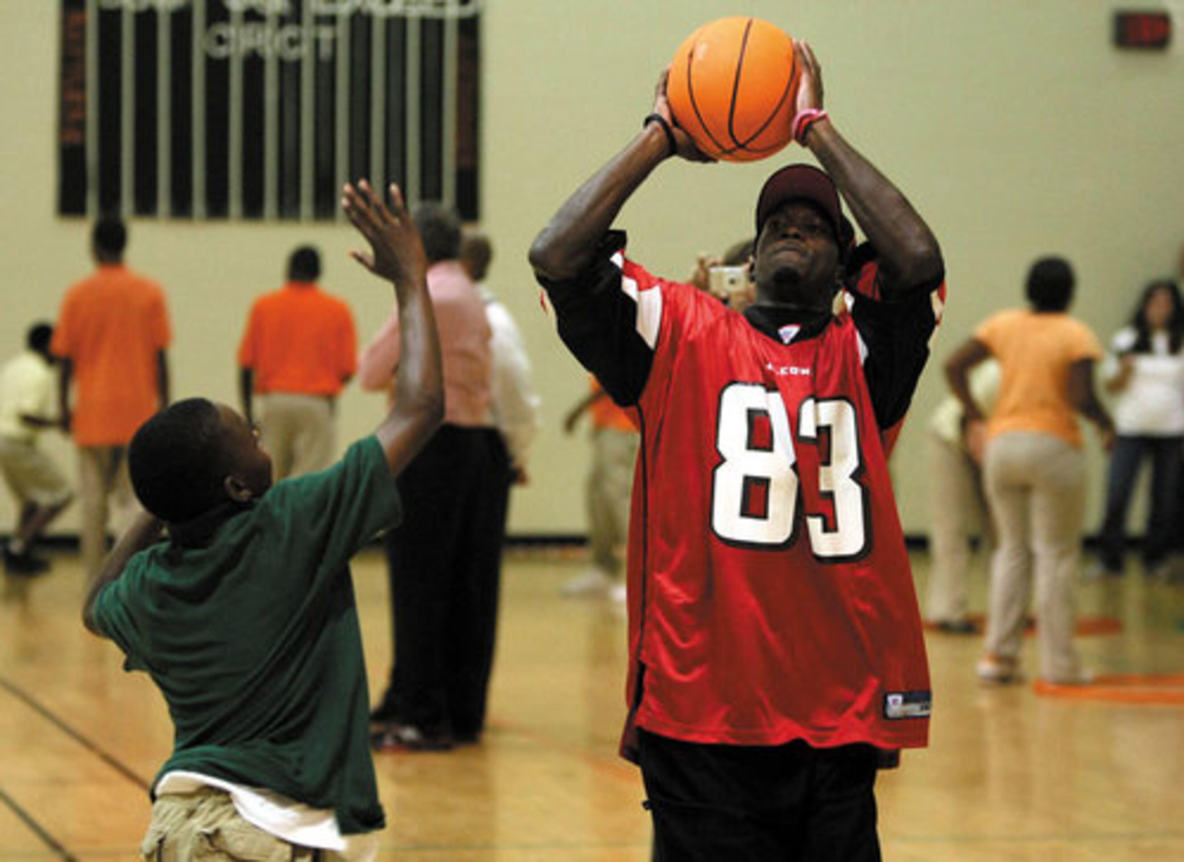 Wide receiver Harry Douglas (83) shoots over 6th grade student Rashaard Sheats as they play one-on-one basketball.