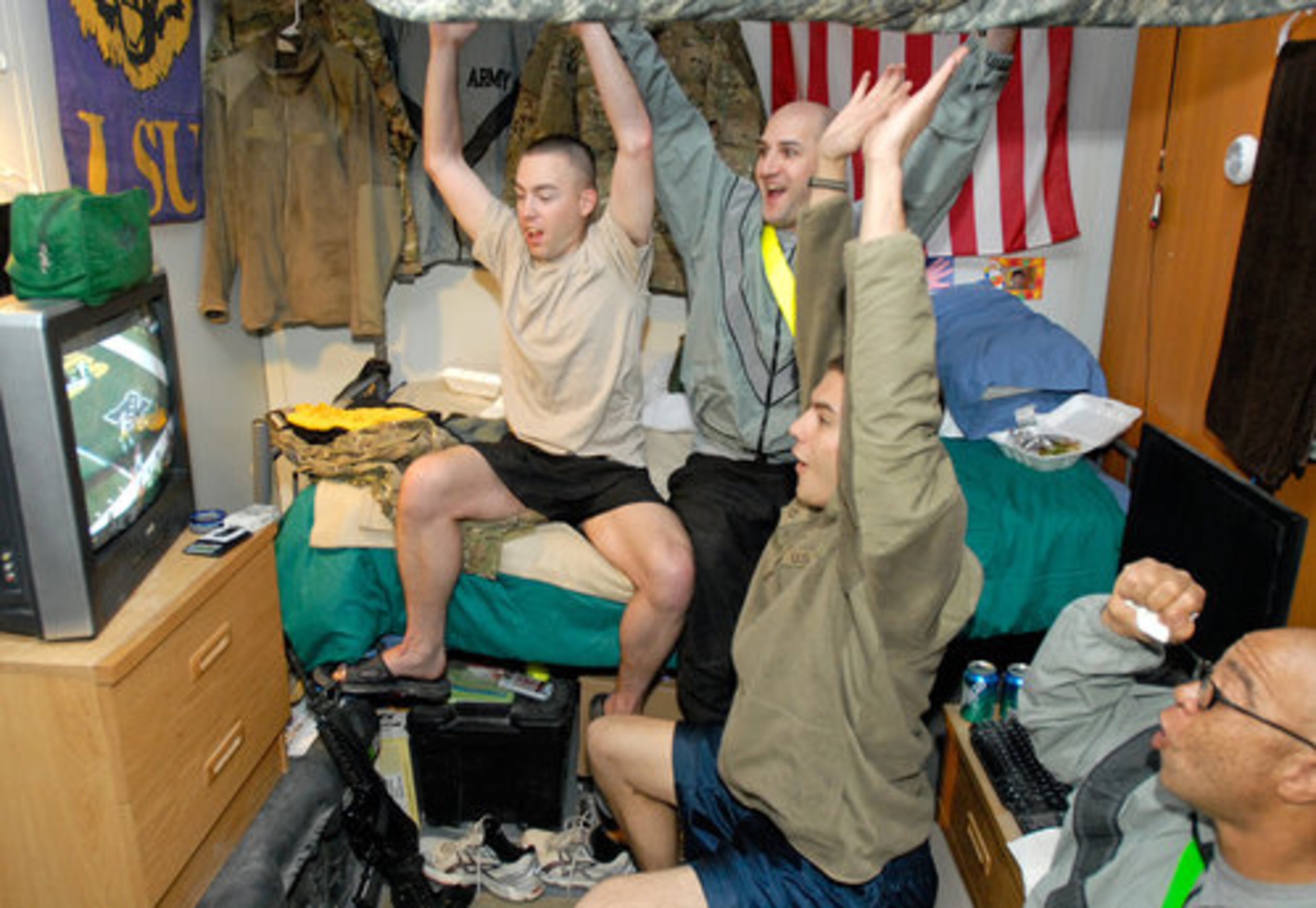 In this photo provided by the International Security Assistance Force, soldiers assigned to the Army's 10th Mountain Division, from Fort Drum, N.Y., react to a first-half touchdown as they watch the broadcast of NFL football's Super Bowl XLV between the Green Bay Packers and the Pittsburgh Steelers, early Monday, Feb. 7, 2011, at Kandahar Airfield in Kandahar, Afghanistan. From left to right are Spc. Justin Webberly, Spc. Don Ellen, Pfc. Matthew Reynolds and Sgt. Cedric Allen.
