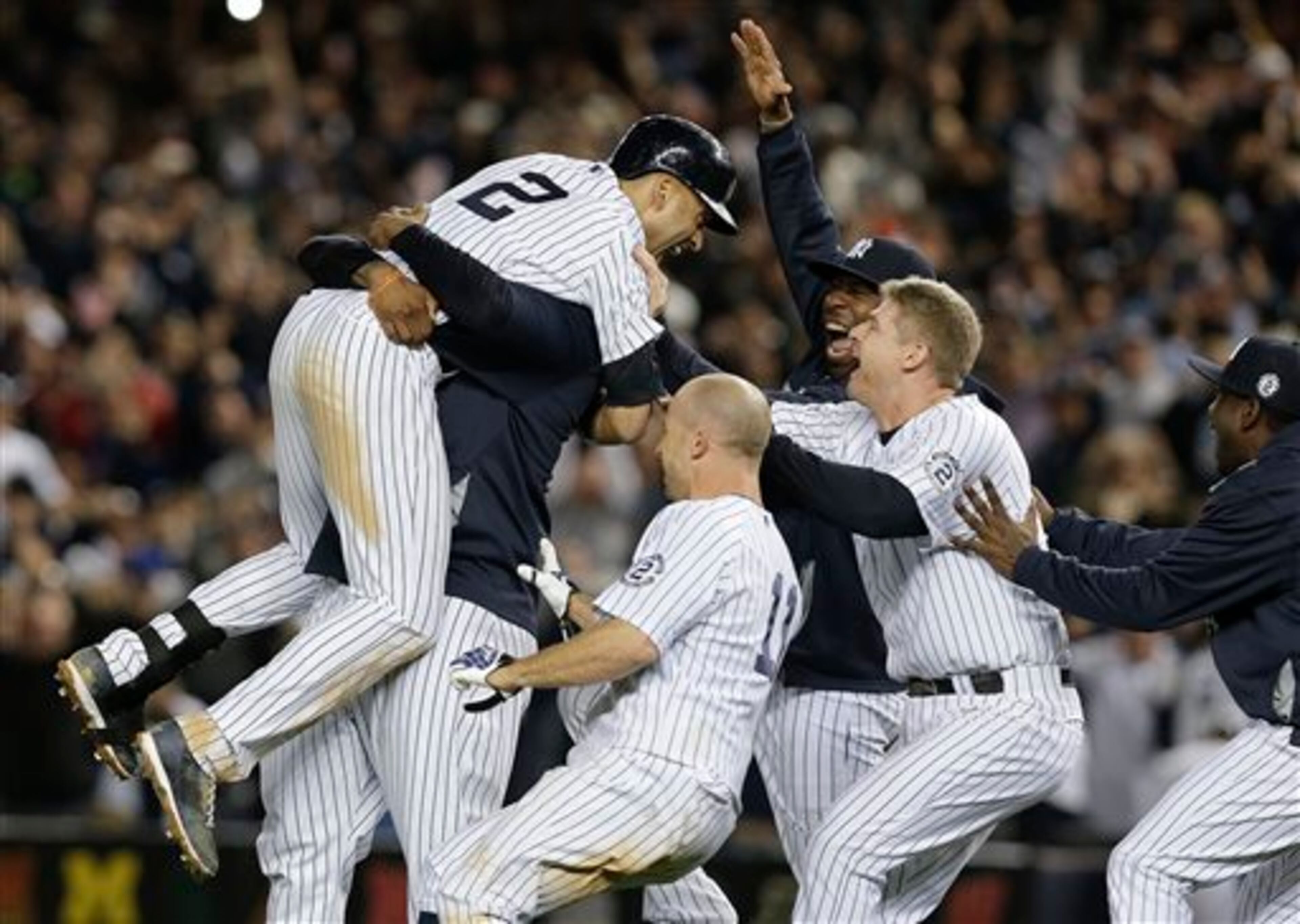 New York Yankees' Derek Jeter (2) is mobbed by teammates after driving in the winning run with a single against the Baltimore Orioles in the ninth inning of a baseball game, Thursday, Sept. 25, 2014, in New York. The Yankees won 6-5. (AP Photo/Julie Jacobson)