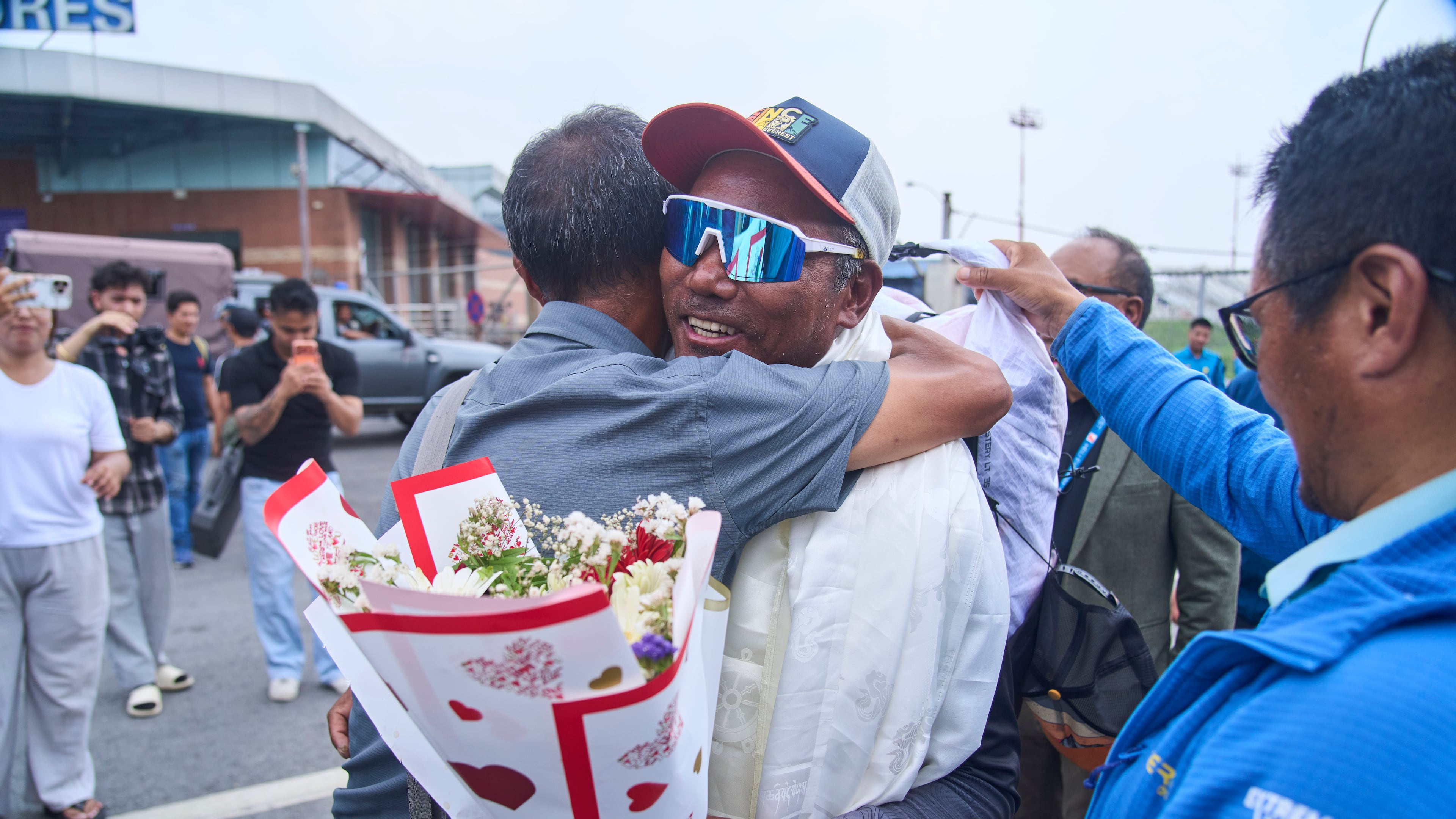 Renowned Sherpa mountain guide Kami Rita, center right, returning from Mount Everest after his record 32nd successful ascent is presented with shawls and flowers as he arrives at an airport in Kathmandu, Nepal, Friday, May 22, 2026. (AP Photo/Niranjan Shrestha)