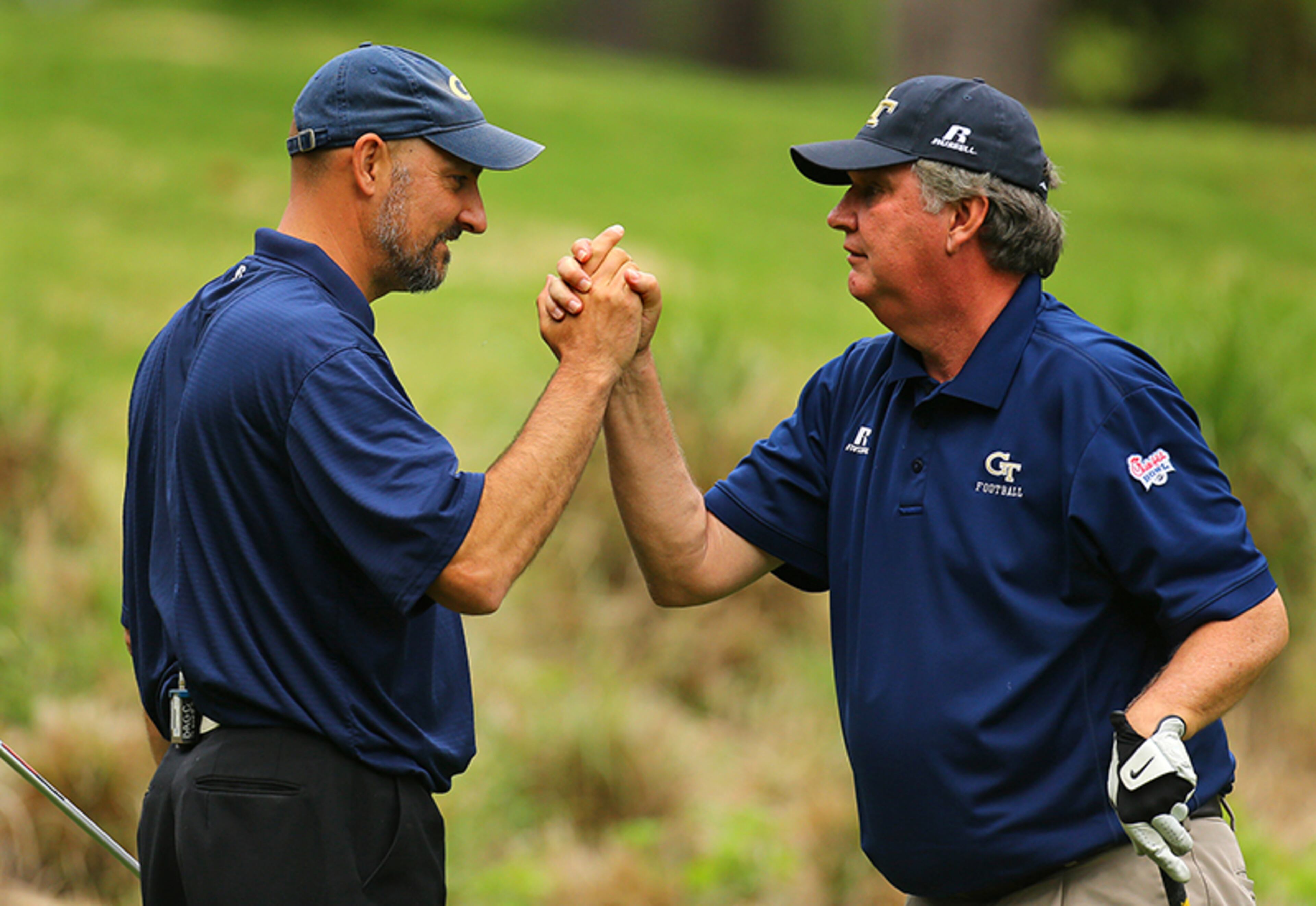 Georgia Tech head coach Paul Johnson (right) celebrates with celebrity alumni Jon Barry (left) after hitting his tee shot close to the cup on the par-3 No. 8 hole on the way to an easy birdie in the Chick-fil-A Bowl Challenge, featuring an 11-team field of NCAA head coaches and celebrity alumni at Reynolds Plantation on Tuesday, April 29, 2014, in Greensboro. Johnson and Barry won the tournament finishing at 13-under par for an event record. Barry played basketball at Georgia Tech and was selected in the first round of the 1992 NBA Draft. Teams compete for a share of the $520,000 scholarship purse for their universities.