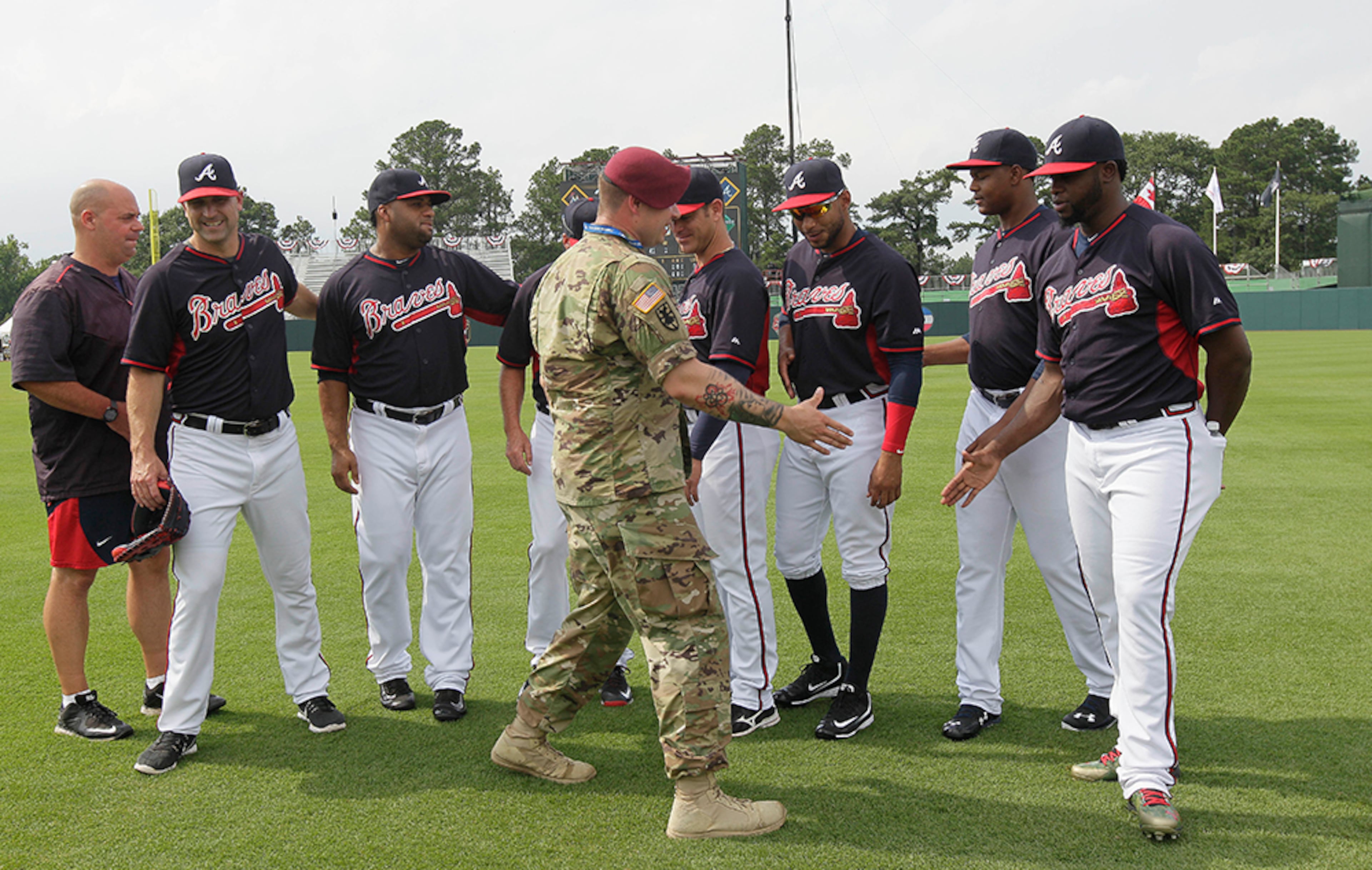 U.S. Army Sgt. Alex Burnett (center front), of the 82nd Airborne Division, greets Atlanta Braves players prior to a baseball game against the Miami Marlins in Fort Bragg, N.C., Sunday, July 3, 2016.