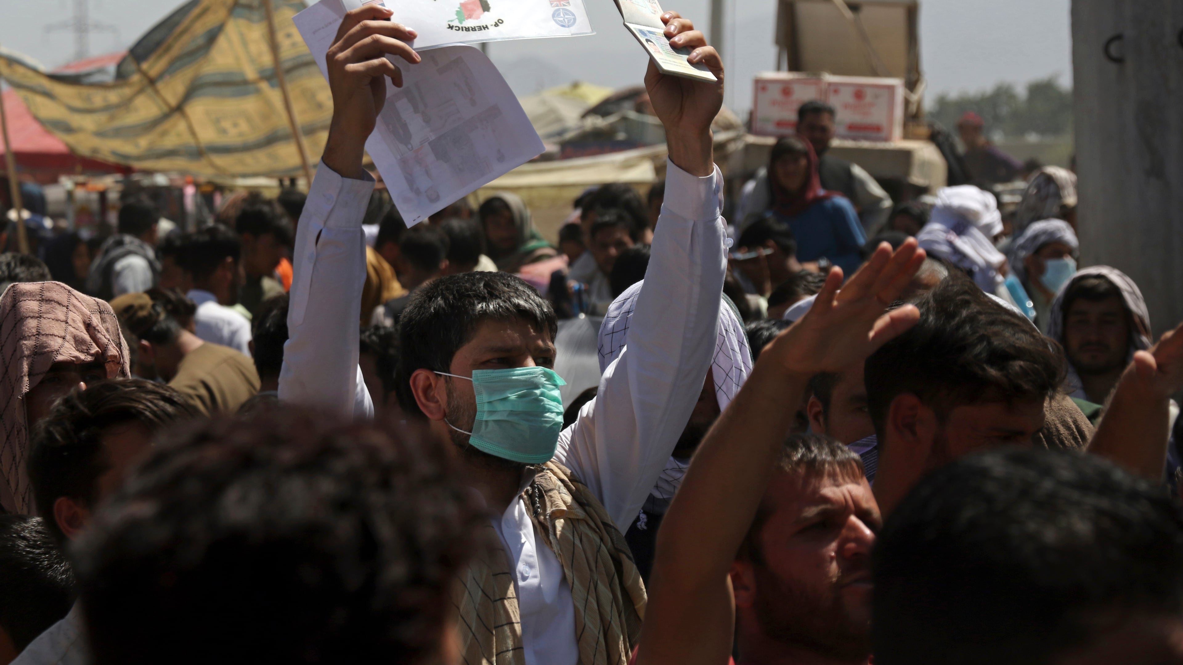 Hundreds of people gathered, some holding documents, near an evacuation control checkpoint on the perimeter of the Hamid Karzai International Airport, in Kabul, Afghanistan, on Aug. 26, 2021. (AP Photo/Wali Sabawoon)