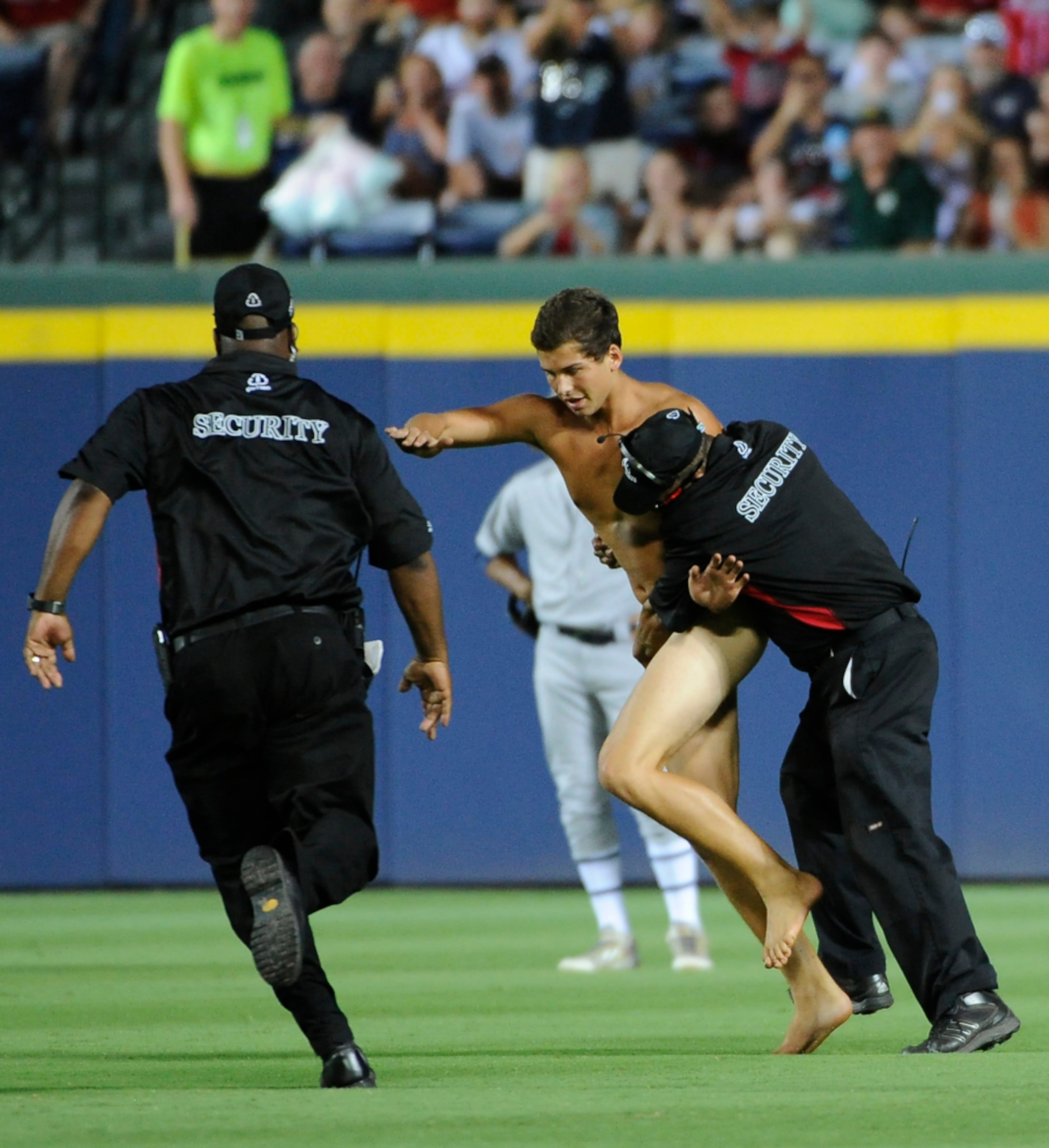 NABBED IN THE OUTFIELD--Time is halted as a streaker is confronted by Atlanta Braves security personnel during the sixth inning of a baseball game against the Oakland Athletics Saturday, Aug. 16, 2014, in Atlanta. (AP Photo/David Tulis)
