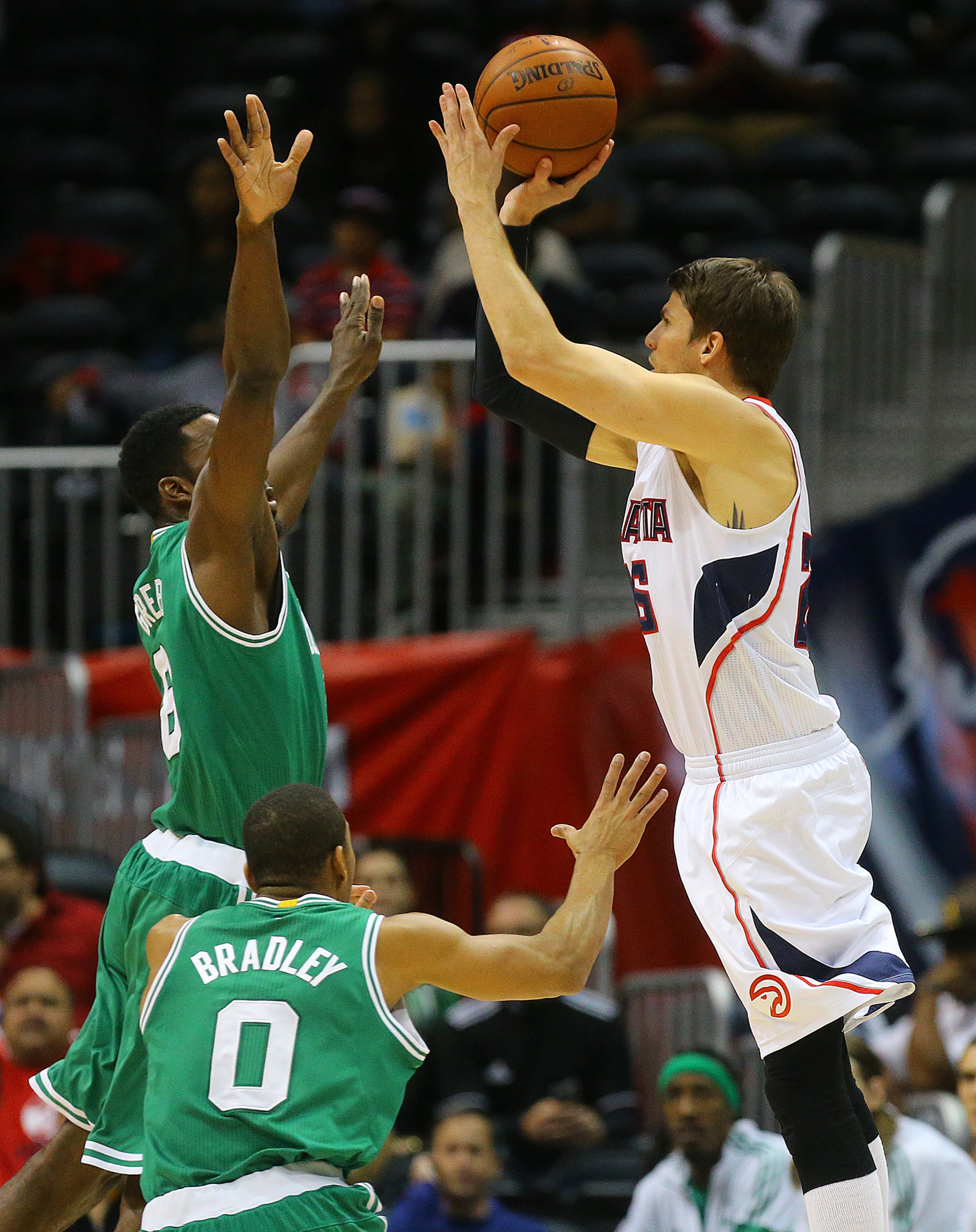 Hawks Kyle Korver hits a three pointer over Celtics Jeff Green during the first half in an NBA basketball game on Tuesday, Dec. 2, 2014, in Atlanta. CURTIS COMPTON / CCOMPTON@AJC.COM