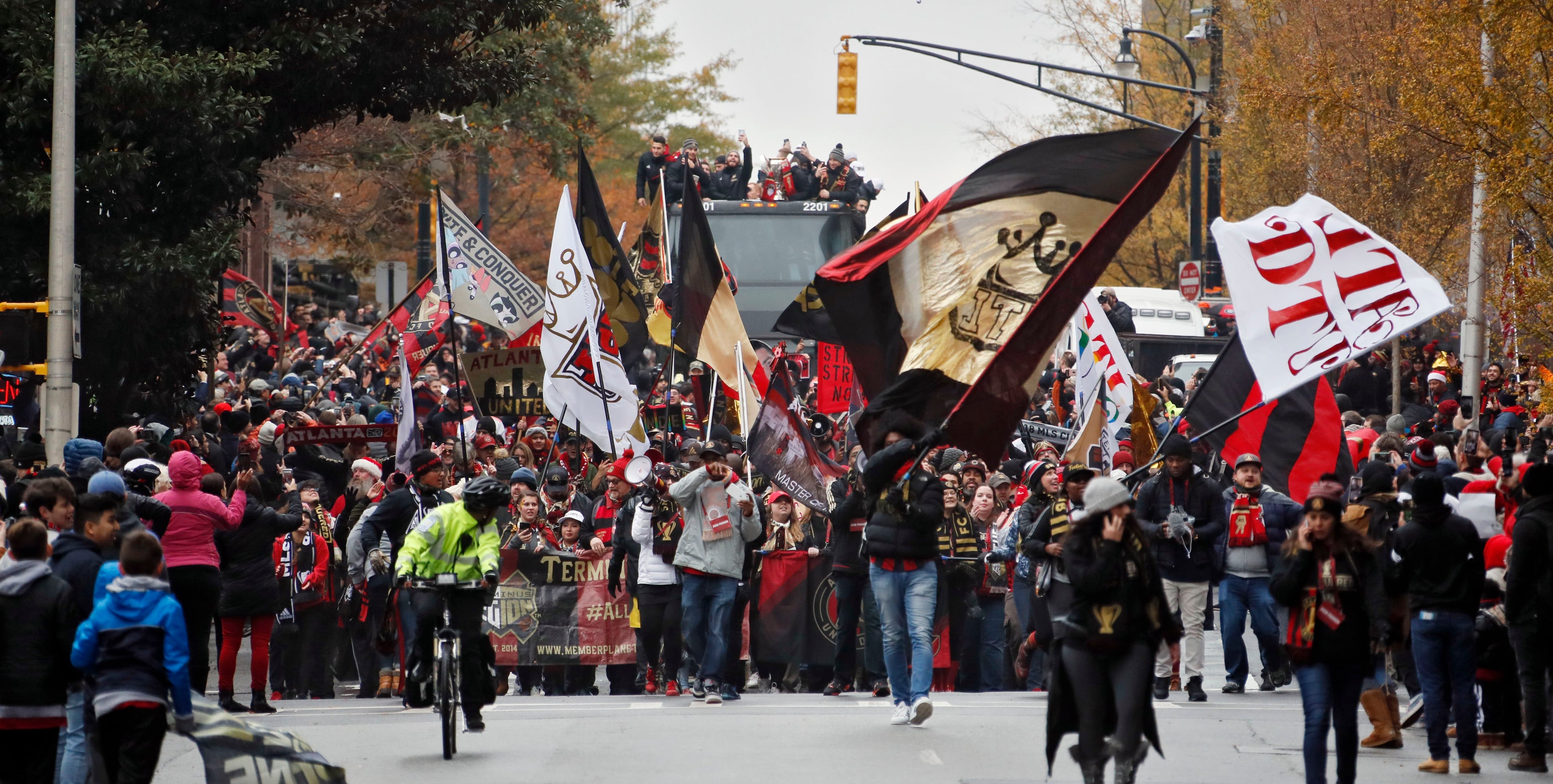 12/10/18 - Atlanta - A double decker bus carrying the team follows cheering fans down Baker Street. Atlanta United fans crowded downtown Atlanta streets to cheer the Atlanta United soccer team and fans in a parade to celebrate winning the MLS Cup, Monday, Dec. 10, 2018. Bob Andres / bandres@ajc.com