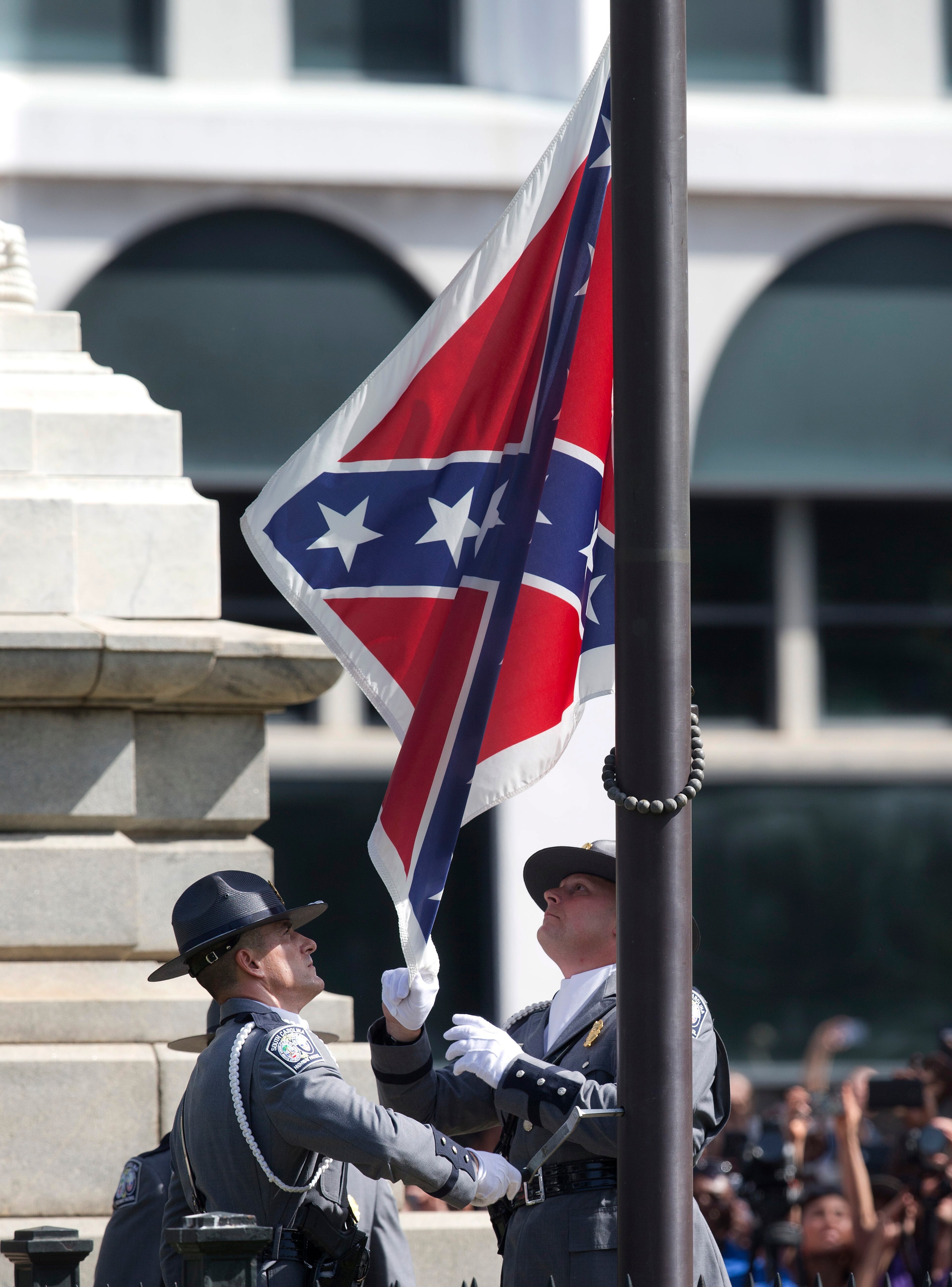 An honor guard from the South Carolina Highway patrol removes the Confederate battle flag from the Capitol grounds in Columbia, S.C., ending its 54-year presence there, on Friday, July 10, 2015. (AP Photo/John Bazemore)