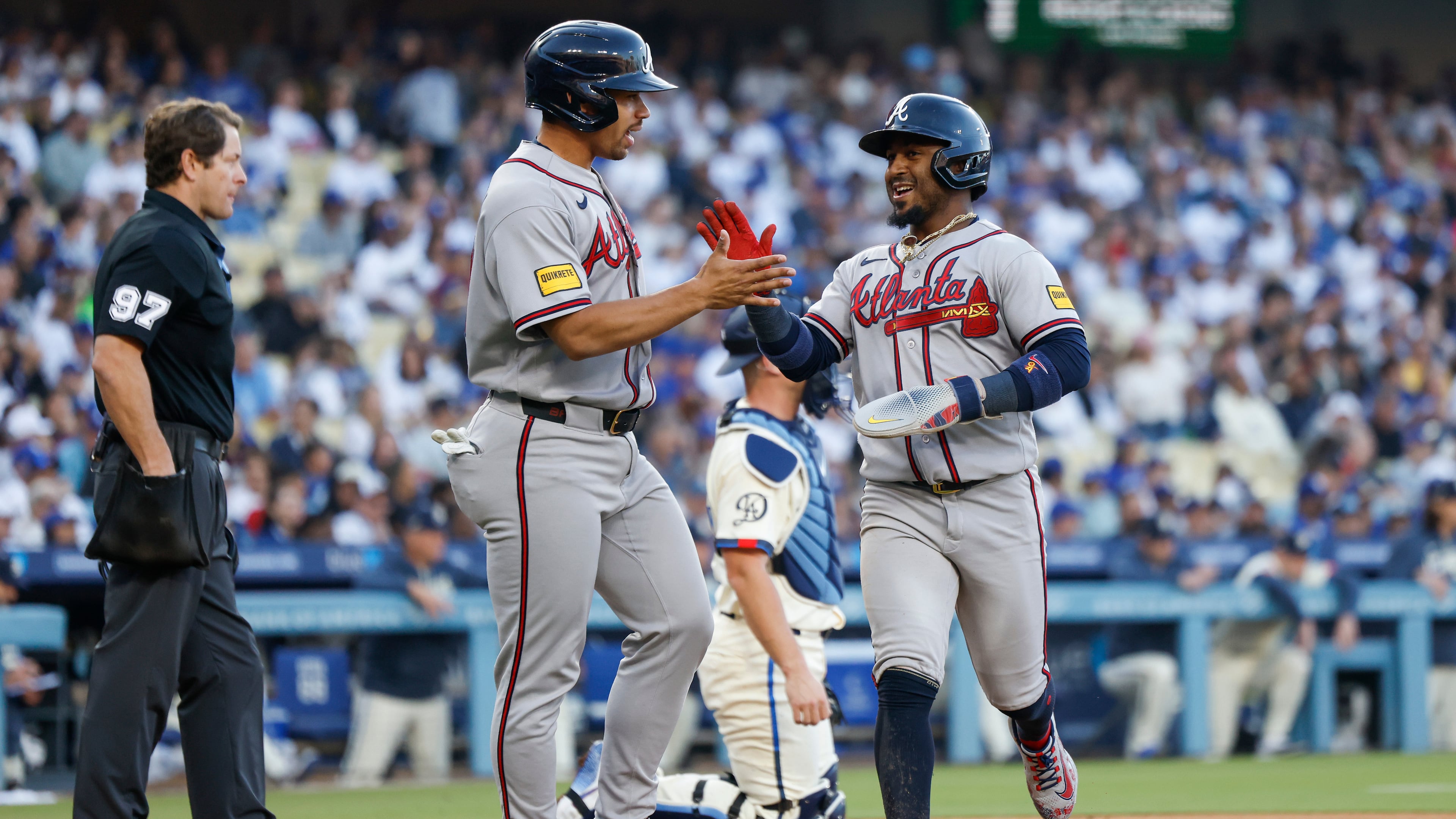 Atlanta Braves designated hitter Drake Baldwin, center left, greets teammate Ozzie Albies, center right, after they scored off a single hit by Braves' Matt Olson (not shown) during the second inning of a baseball game against the Los Angeles Dodgers, Saturday, May 9, 2026, in Los Angeles. (AP Photo/Caroline Brehman)
