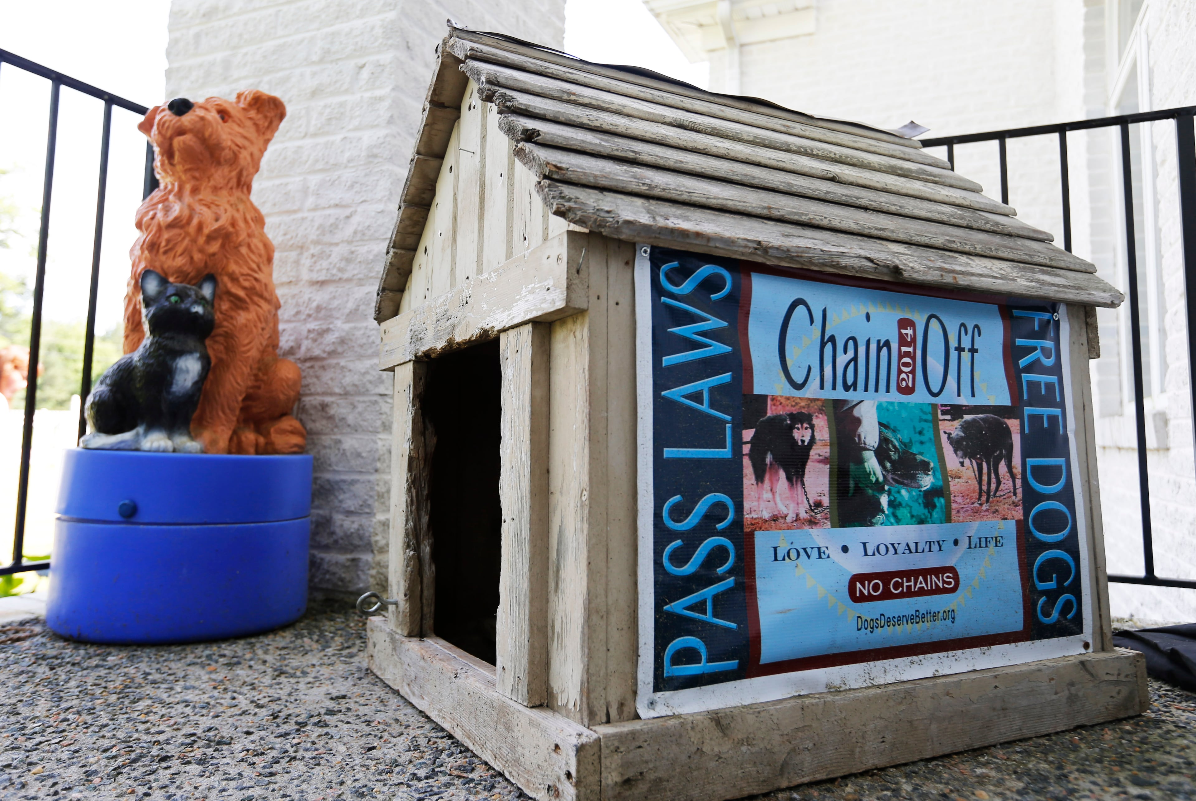 A statue of a dog as well as a dog house with a poster adorn the front steps of the Good Newz Rehab Center, the former home of NFL football quarterback and former Atlanta Falcons player Michael Vick's dogfighting operation in Smithfield, Va., Monday, June 15, 2015. The anti-chaining organization Dogs Deserve Better bought the 15-acre compound and its five-bedroom house in 2011. The property where dogs were once brutalized is now a refuge for dogs rescued from a life of being chained or penned. (AP Photo/Steve Helber)