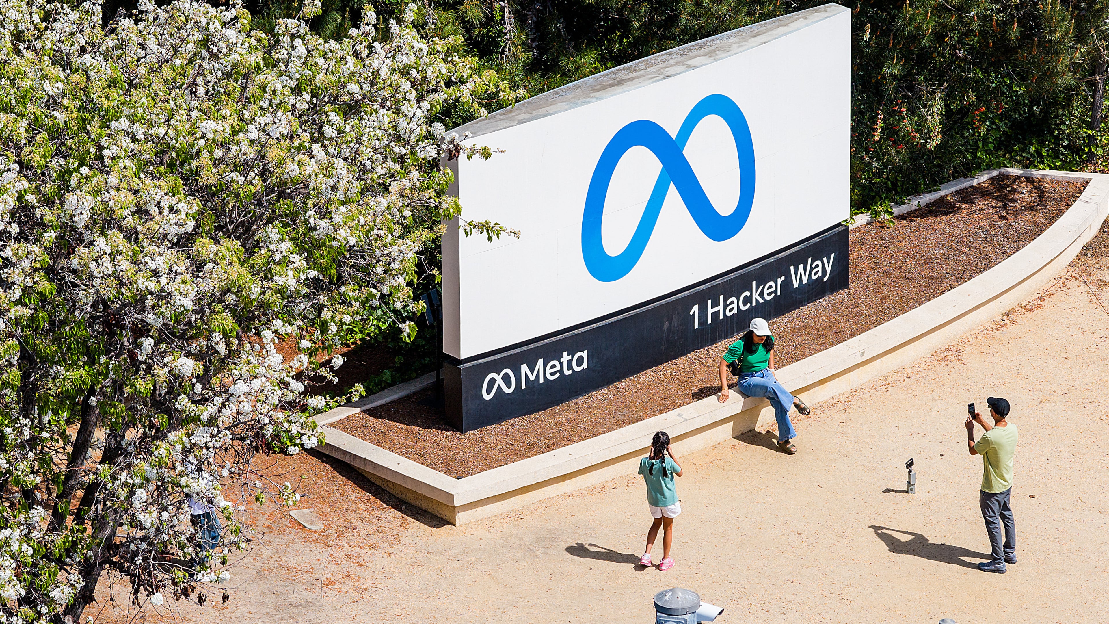 FILE - Visitors take photos at a sign outside Meta headquarters March 26, 2026, in Menlo Park, Calif. (AP Photo/Noah Berger, File)