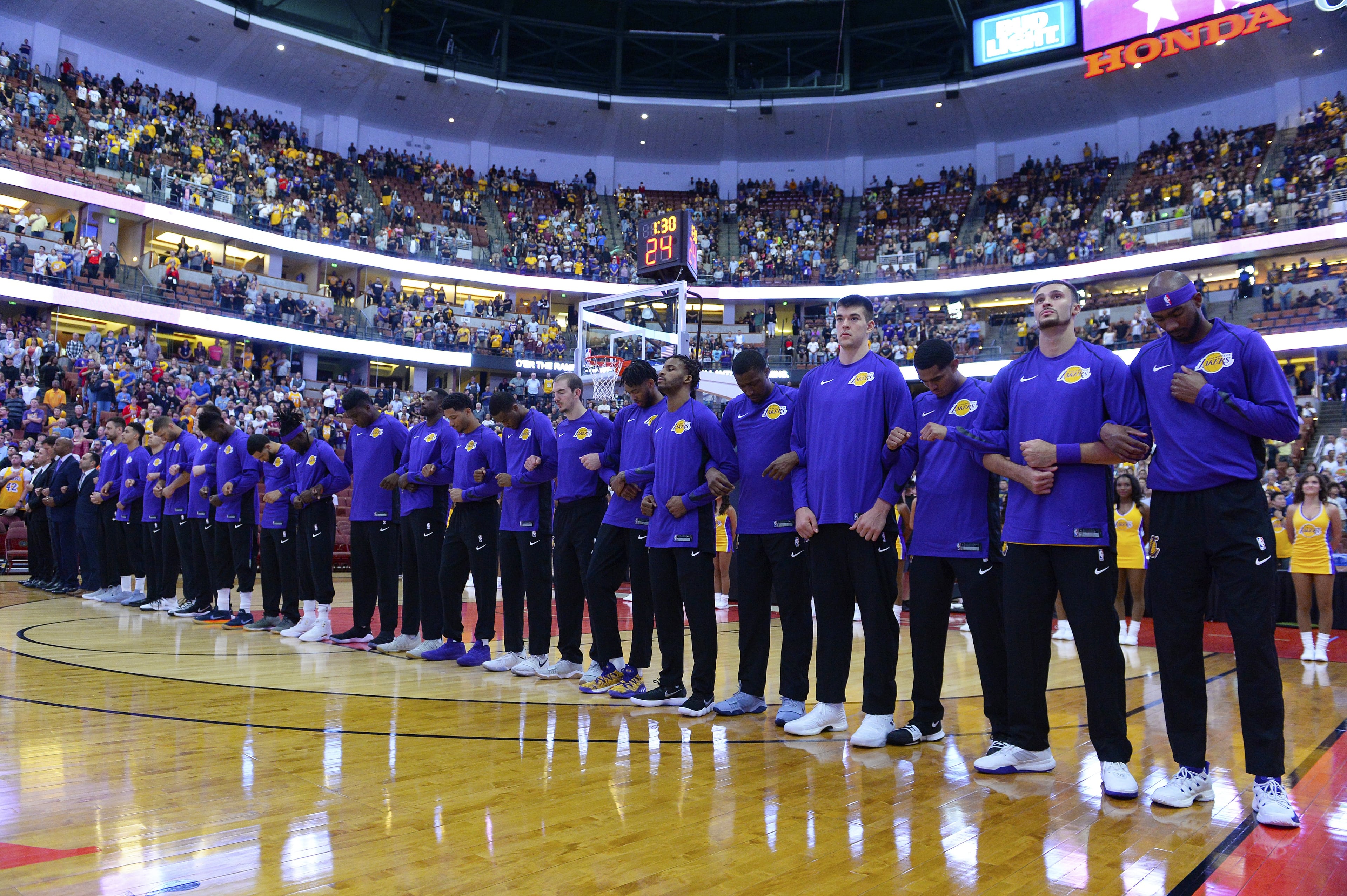 The Los Angeles Lakers lock arms during the national anthem before the start of the game against the Minnesota Timberwolves on September 30, 2017.