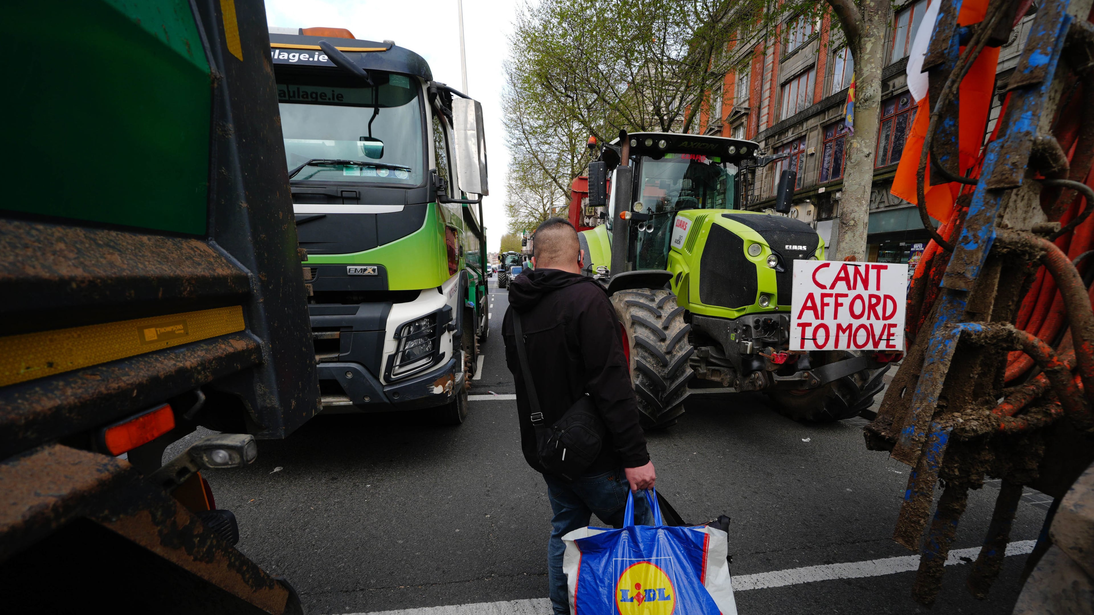 A man walks in between vehicles parked on O'Connell Street on the second day of a national fuel protest against rising fuel prices, in Dublin, Ireland, Wednesday April 8, 2026. (Brian Lawless/PA via AP)