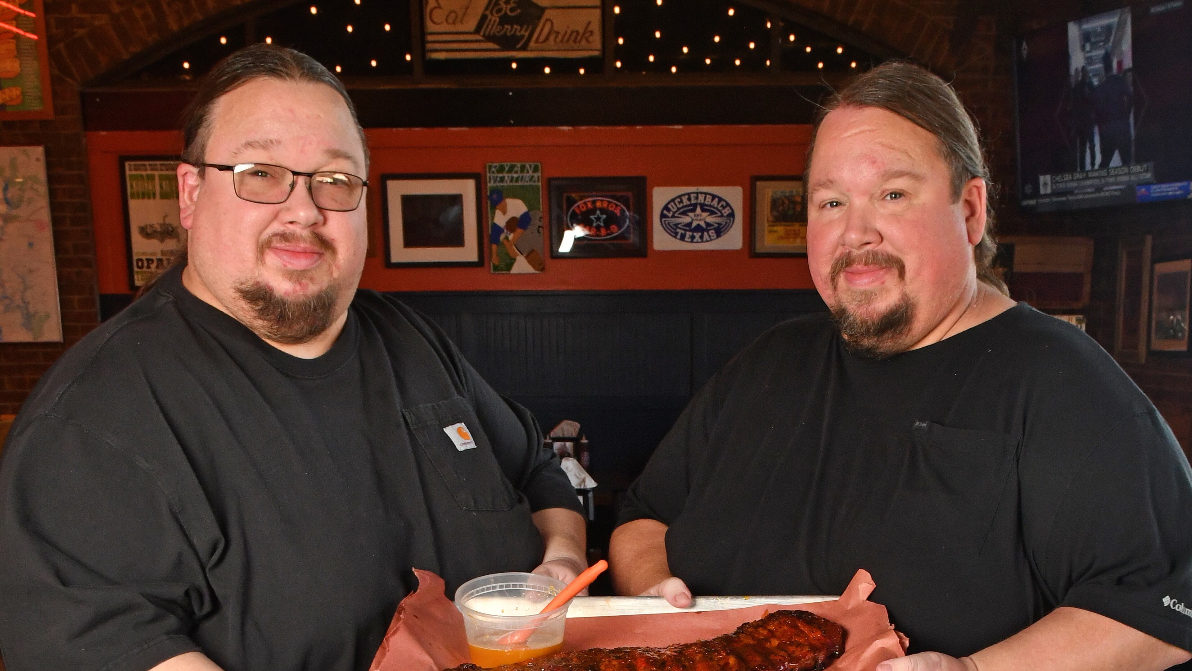 240620 Brookhaven, Ga: Brothers Justin (glasses) and Jonathan Fox, co-owners of Atlanta-based Fox Brothers Barbecue, show how to use their ÒBrookhaven Rib GlazeÓ - (note the glazeÕs title may change according to Jonathan Fox) on a rack of BBQ Baby Back Ribs at their recently opened Brookhaven location at, 4058 Peachtree Road, Brookhaven Ga. 30319. Photo for AJC Food section story on Marinades, by C.W. Cameron. Photos taken Thursday June 20, 2024. Food styling by Jonathan and Justin Fox. 071424MARINADES (CHRIS HUNT FOR THE ATLANTA JOURNAL-CONSTITUTION)