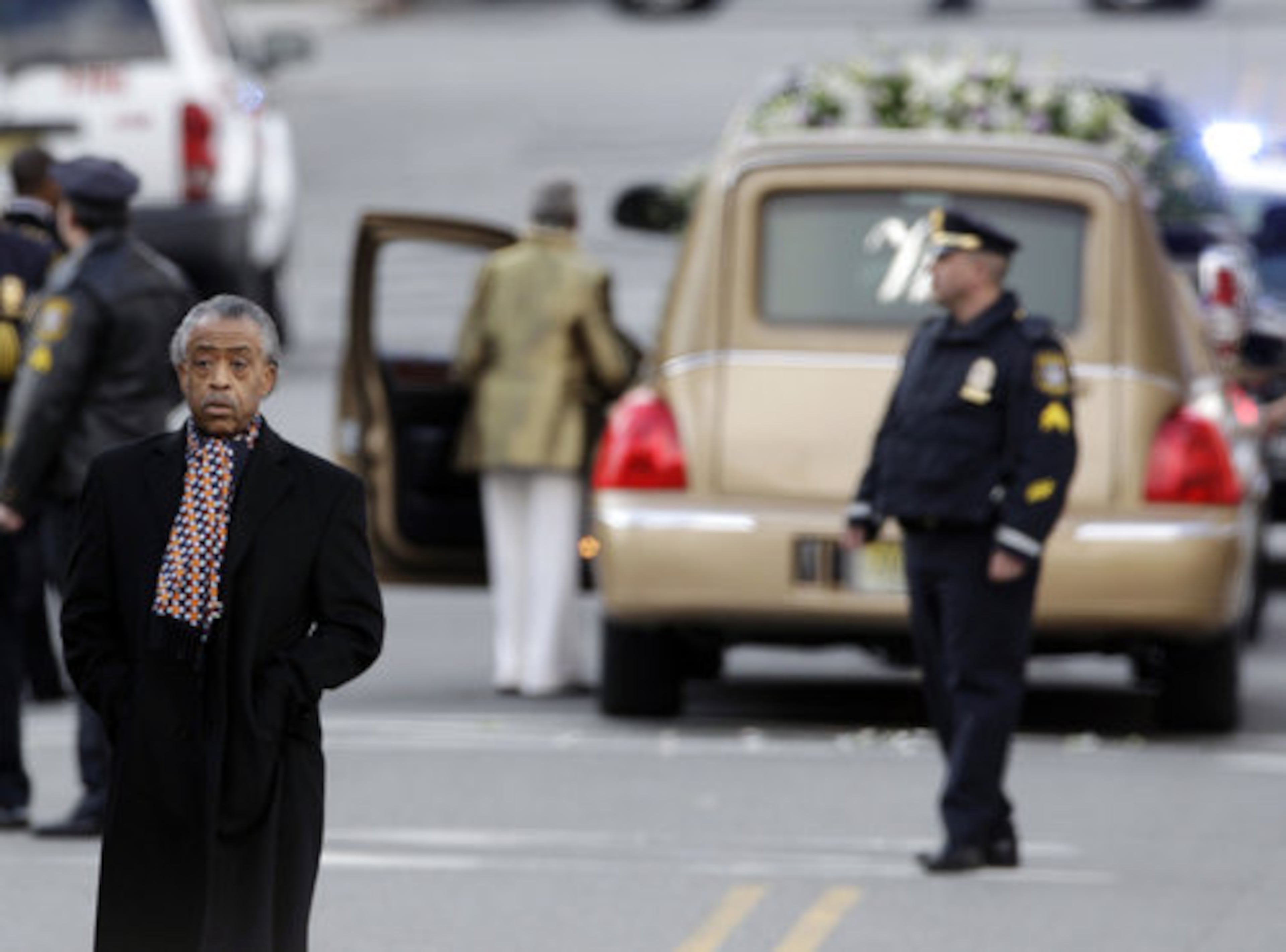The Rev. Al Sharpton, left, leaves after a funeral service for Whitney Houston at New Hope Baptist Church in Newark, N.J., Saturday, Feb. 18, 2012.