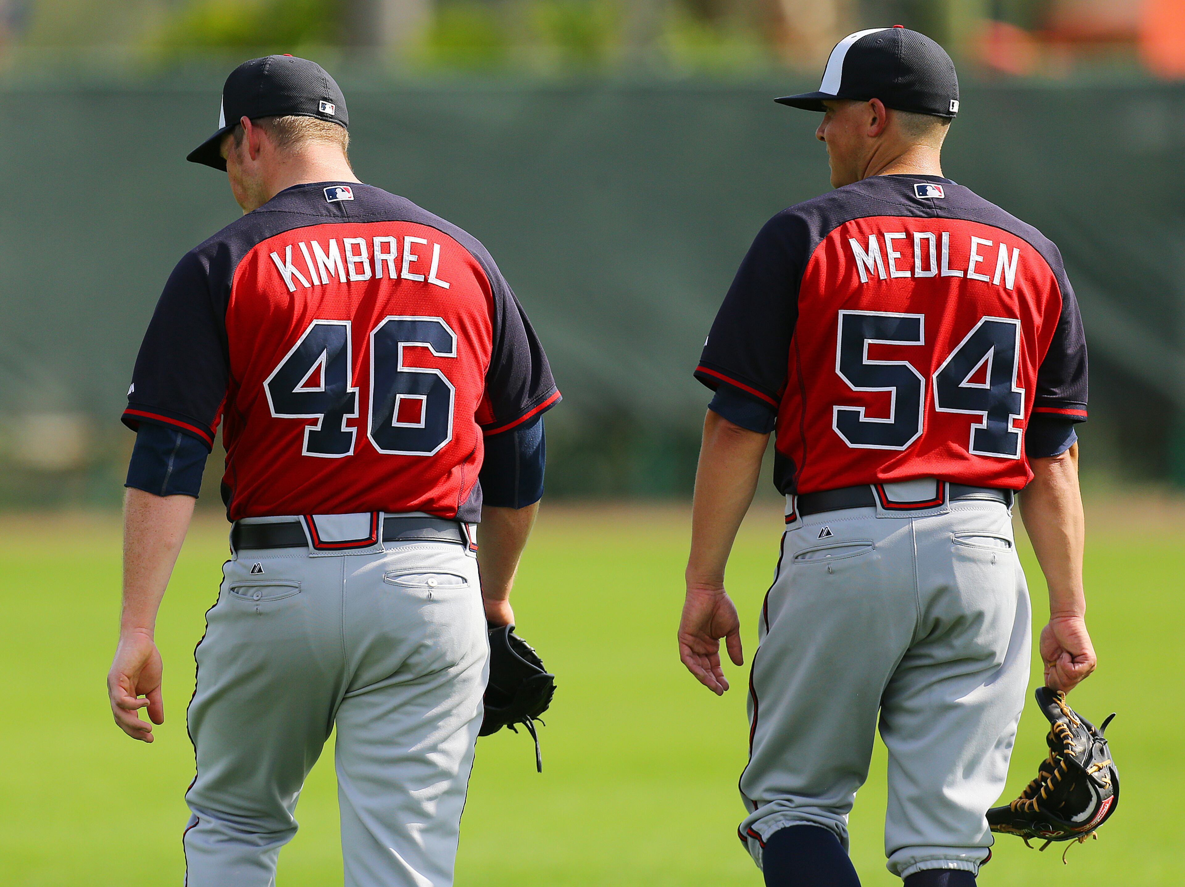 Braves pitchers Craig Kimbrel and Kris Medlen walk off the field after givinig Braves batters their first stout test of spring training pitching back to back from the mound on Sunday, Feb. 23, 2014, in Lake Buena Vista, FL. CURTIS COMPTON / CCOMPTON@AJC.COM