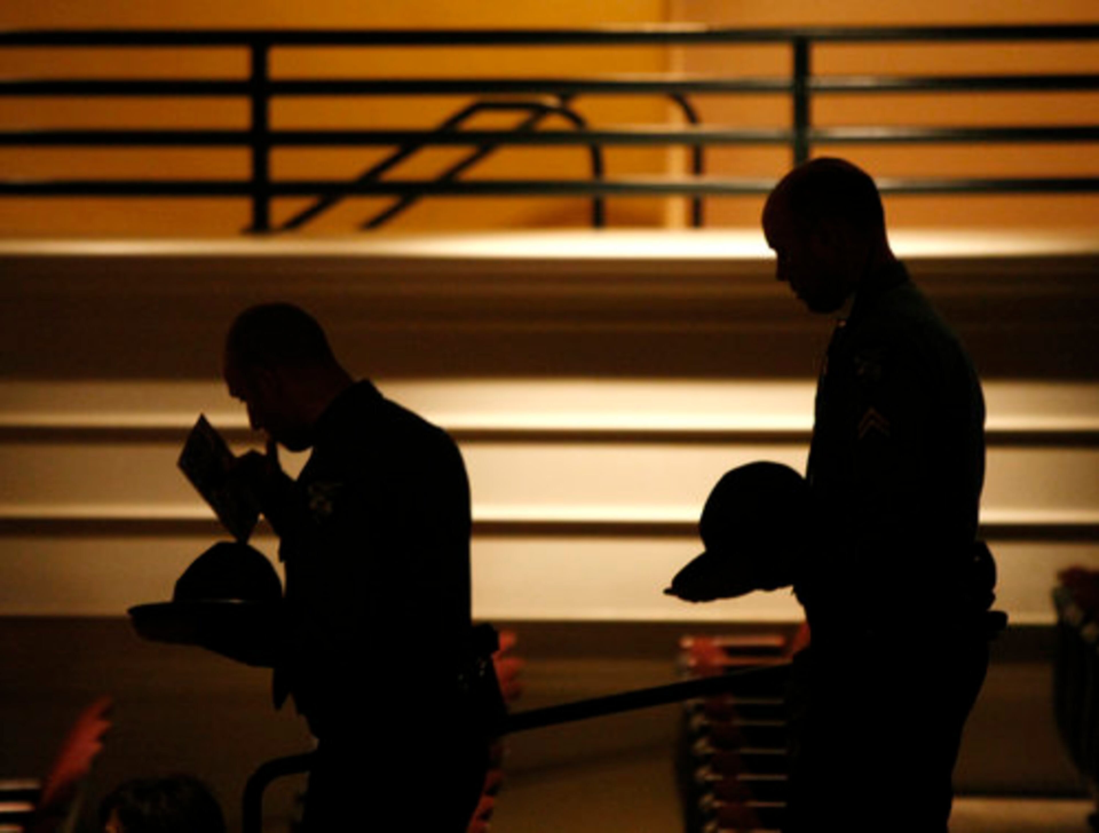 Law enforcement officers remove their hats as they enter the memorial service of slain Athens Senior Police Officer Elmer "Buddy" Christian at the Classic Center Theatre in Athens on Sunday, March 27, 2011.