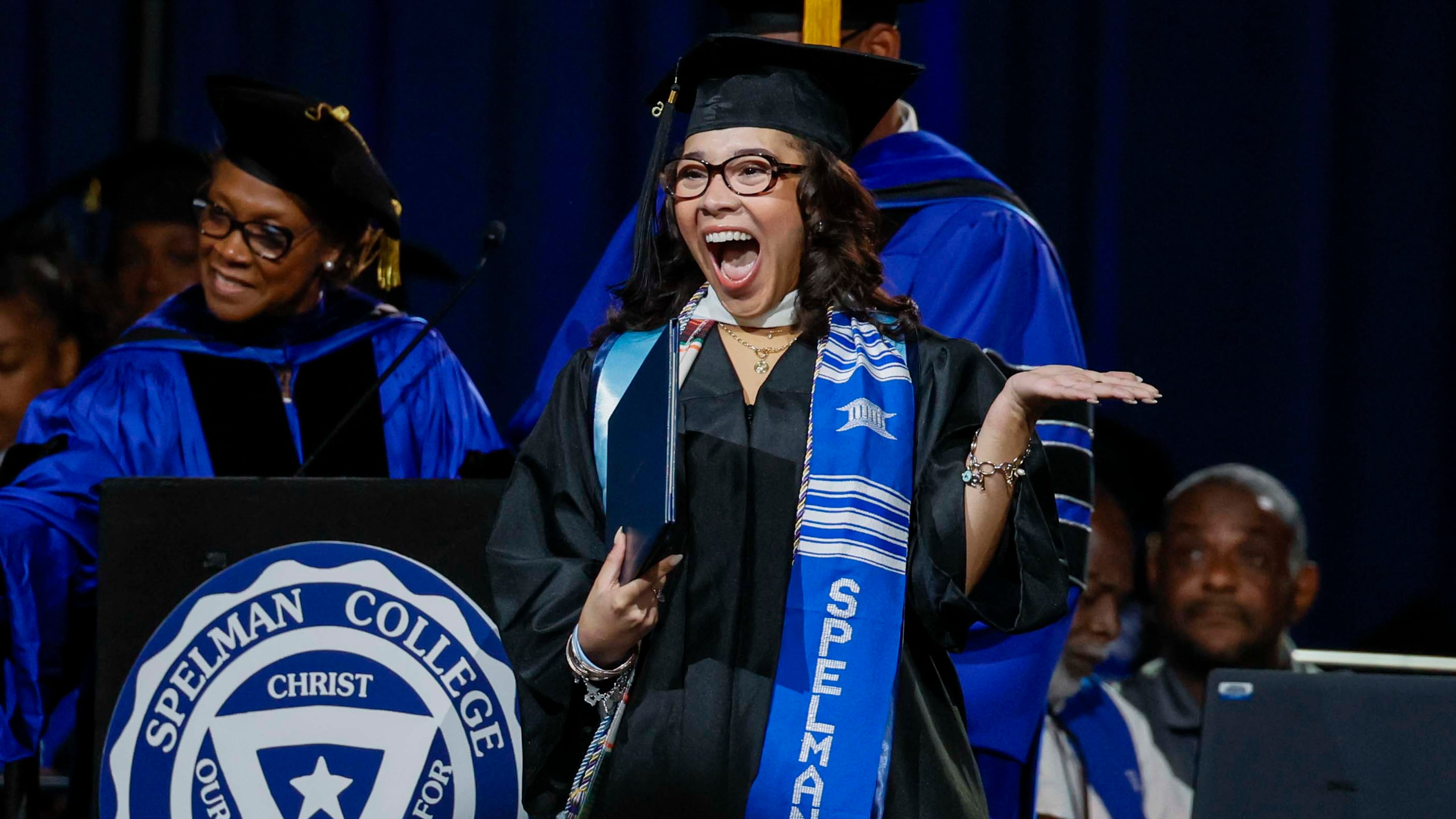 A graduate reacts after receiving her diploma during Spelman College commencement in May at the Georgia International Convention Center in College Park. Spelman's graduation rate is 76%, highest among all historically Black colleges and universities. (Miguel Martinez/AJC)