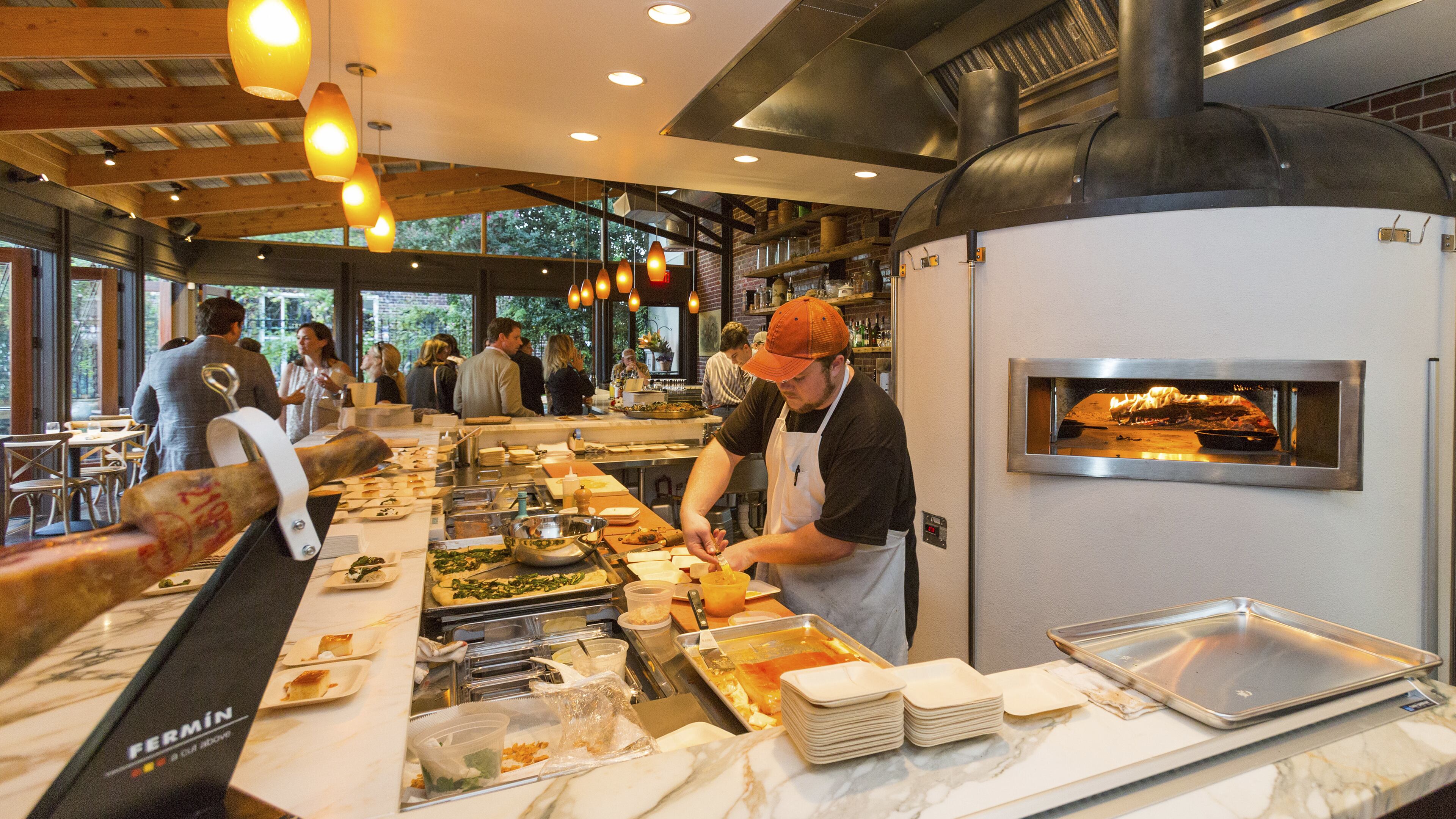 An undated handout photo of a chef preparing a dish at OvenBird, a restaurant that only uses a wood-burning hearth in Birmingham, Ala. Inspired by the live-fire cooking traditions of Spain, Uruguay, Portugal, and Argentina, the restaurant’s cast-iron hearth also plays homage to Birmingham’s long history as a center of iron and steel production. (Handout via The New York Times)