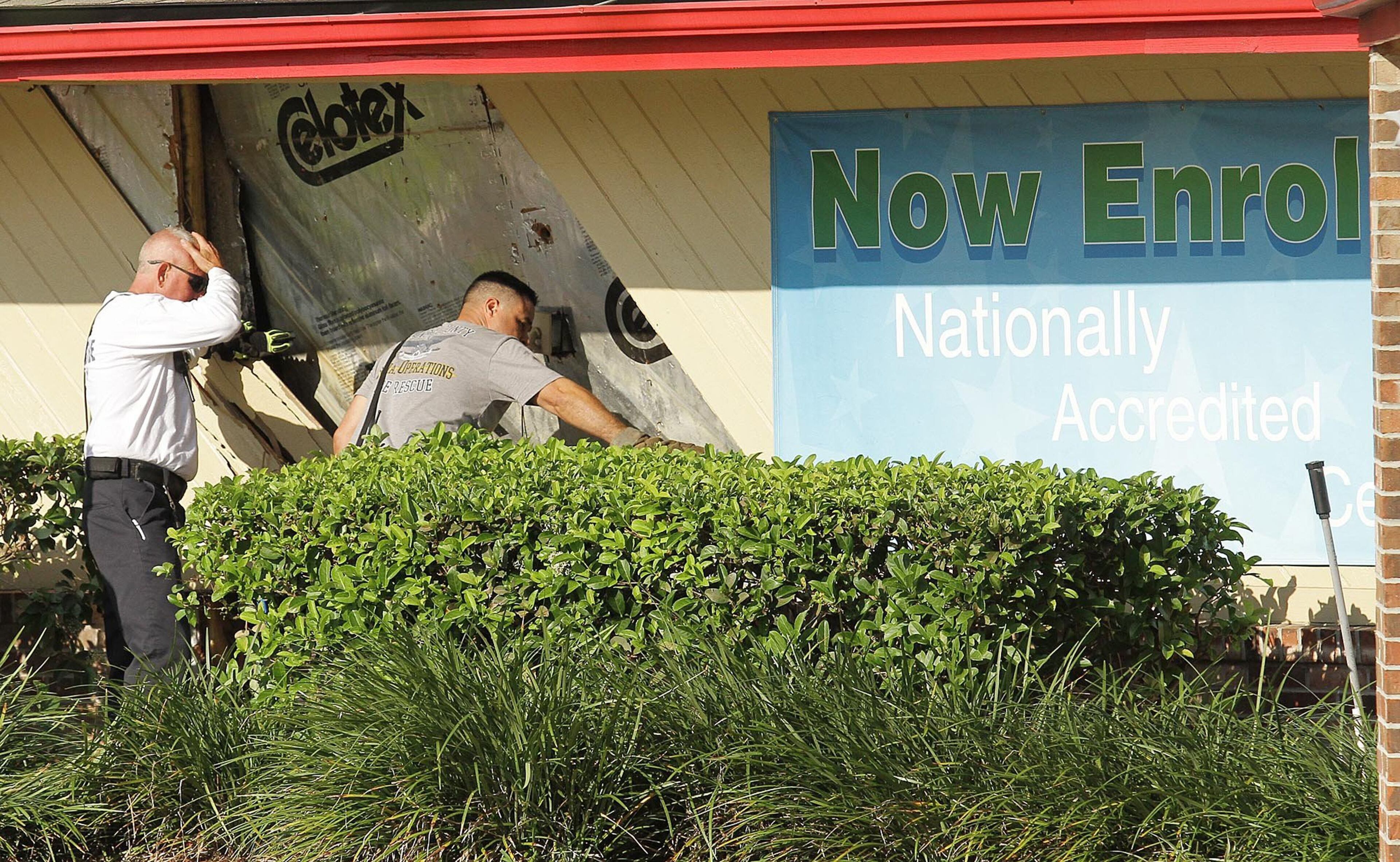 Workers examine damage to the building after several children were injured when a car crashed into KinderCare Learning Center on Wednesday, April 9, 2014, in Winter Park, Fla. (Stephen M. Dowell, Orlando Sentinel/MCT)