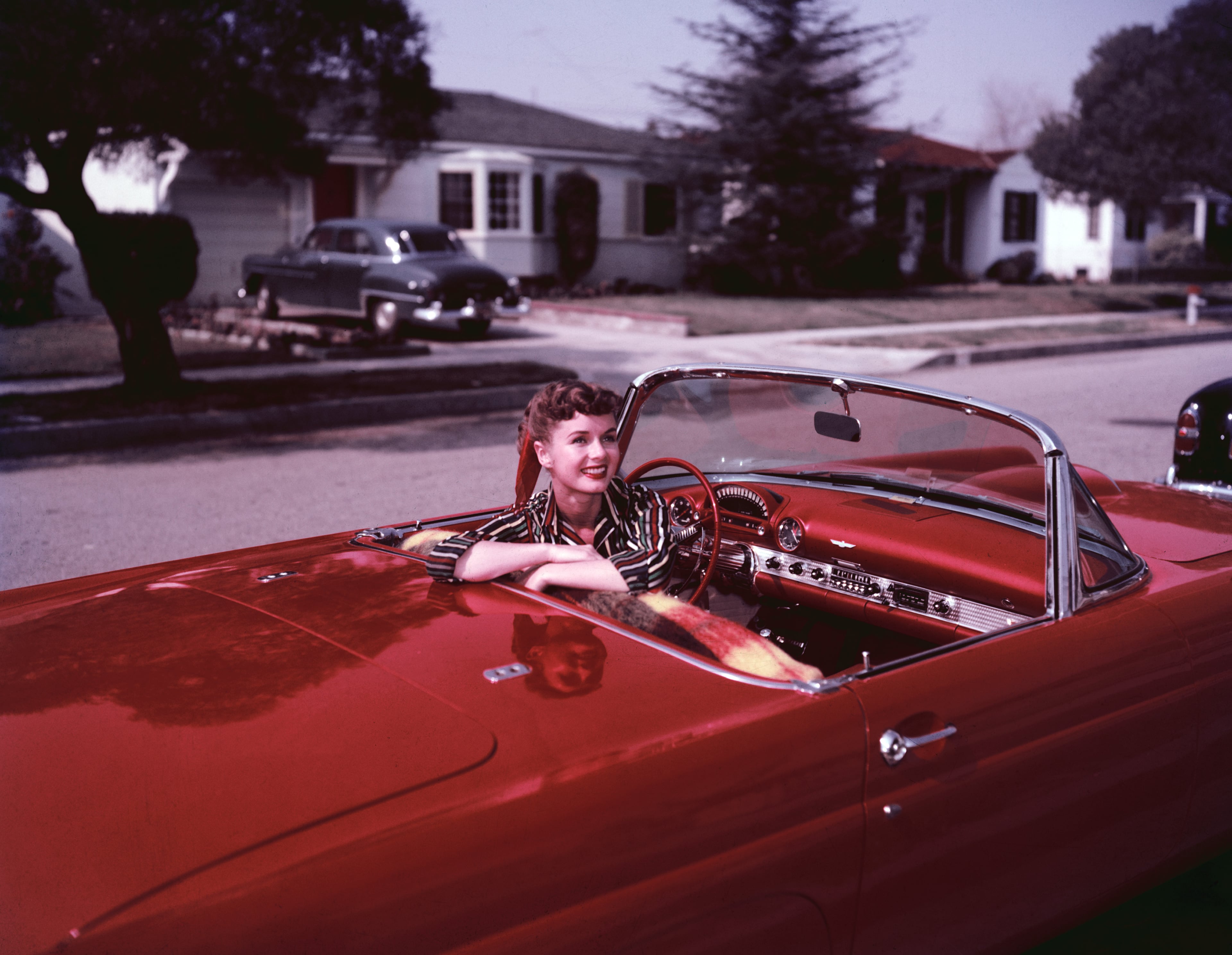American actress Debbie Reynolds at the wheel of a parked red convertible, circa 1955. (Photo by Archive Photos/Getty Images)