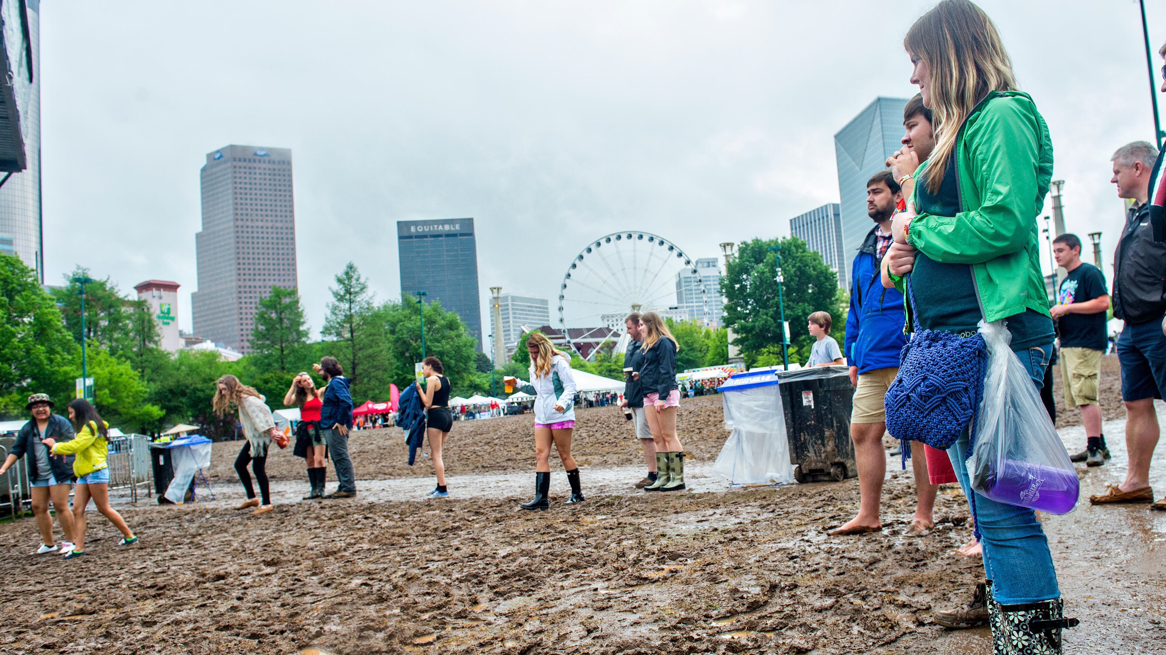 April 19, 2015 Atlanta - Amie Holmes (right) watches as people try to cross the mud pit that used to be a field of grass during the last day of the SweetWater 420 Fest at Centennial Olympic Park in Atlanta on Sunday, April 19, 2015. Delta Rae, Slightly Stoopid, Moe., 311, Shine Live, The Wailers and many more artists performed on the last of the three day music festival. JONATHAN PHILLIPS / SPECIAL