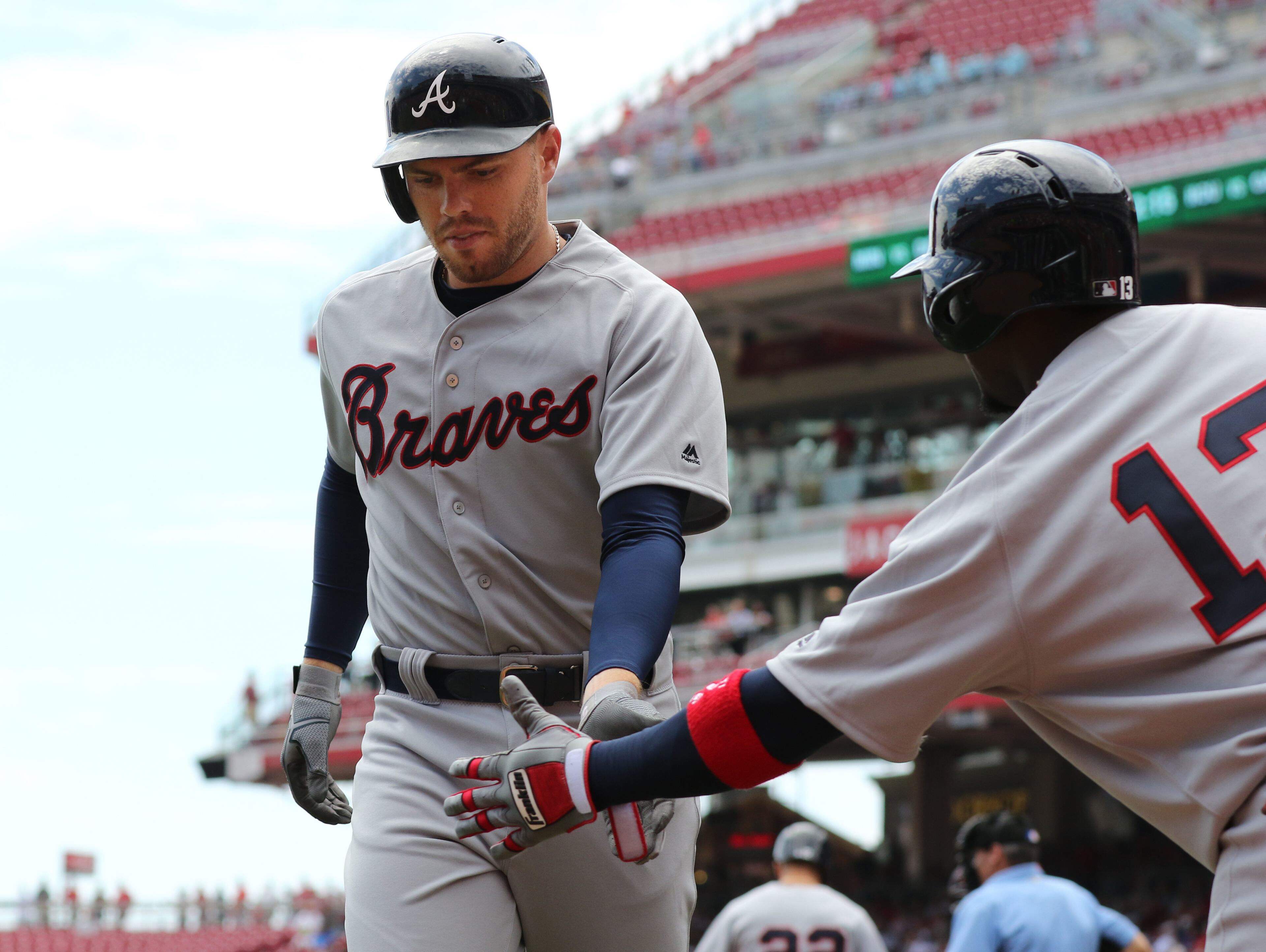 Atlanta Braves Freddie Freeman, left, is congratulated on a solo home run off Cincinnati Reds starting pitcher Anthony DeSclafani by Adonis Garcia (13) during the first inning of a baseball game, Wednesday, July 20, 2016, in Cincinnati. (AP Photo/Gary Landers)