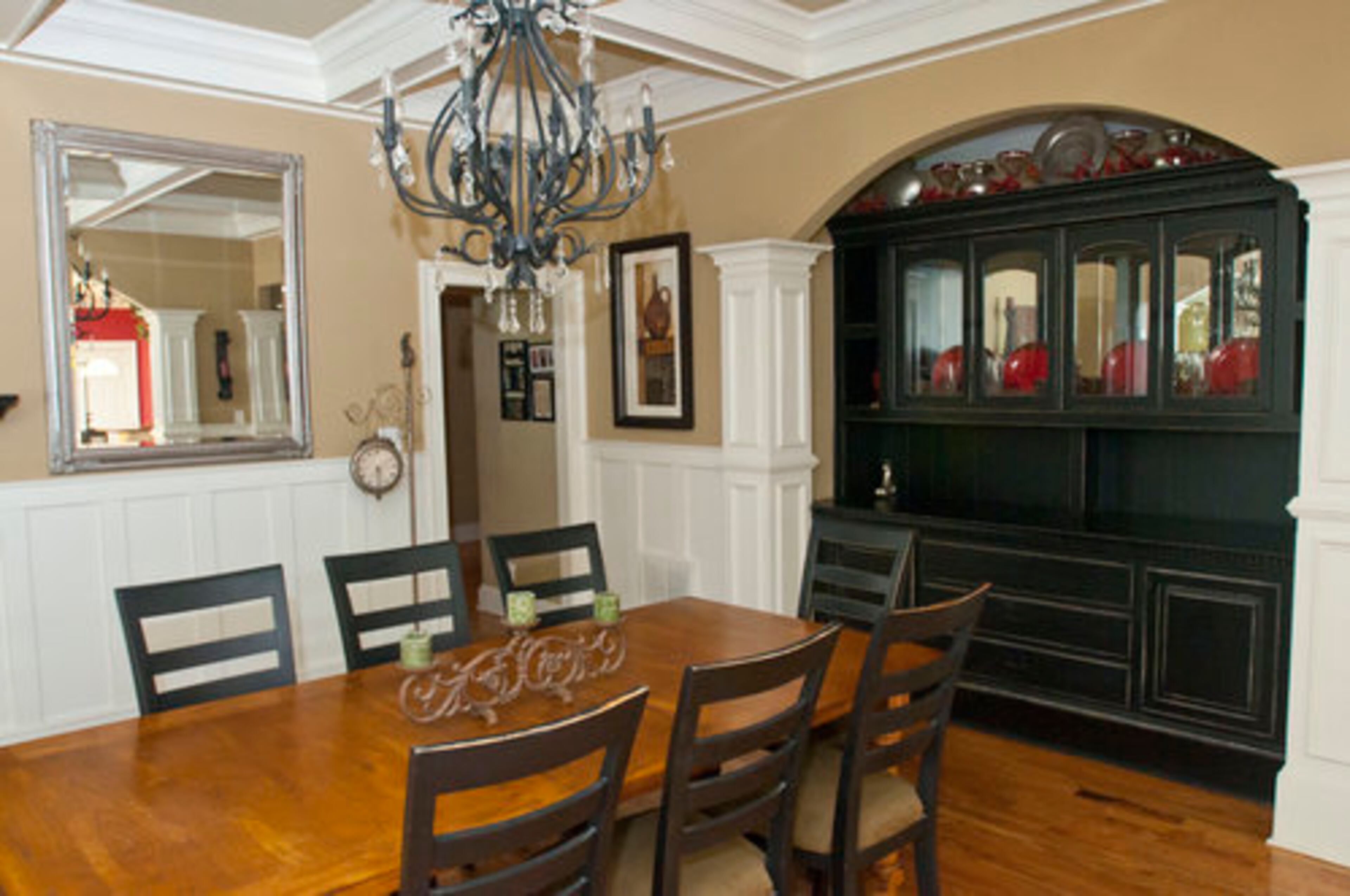 The dining room has details such as judges paneling and a coffered ceiling. A hutch is a perfect fit in the archway. Duane's dad had built the part of the piece with glass, and when he died, Duane decided to create a hutch.