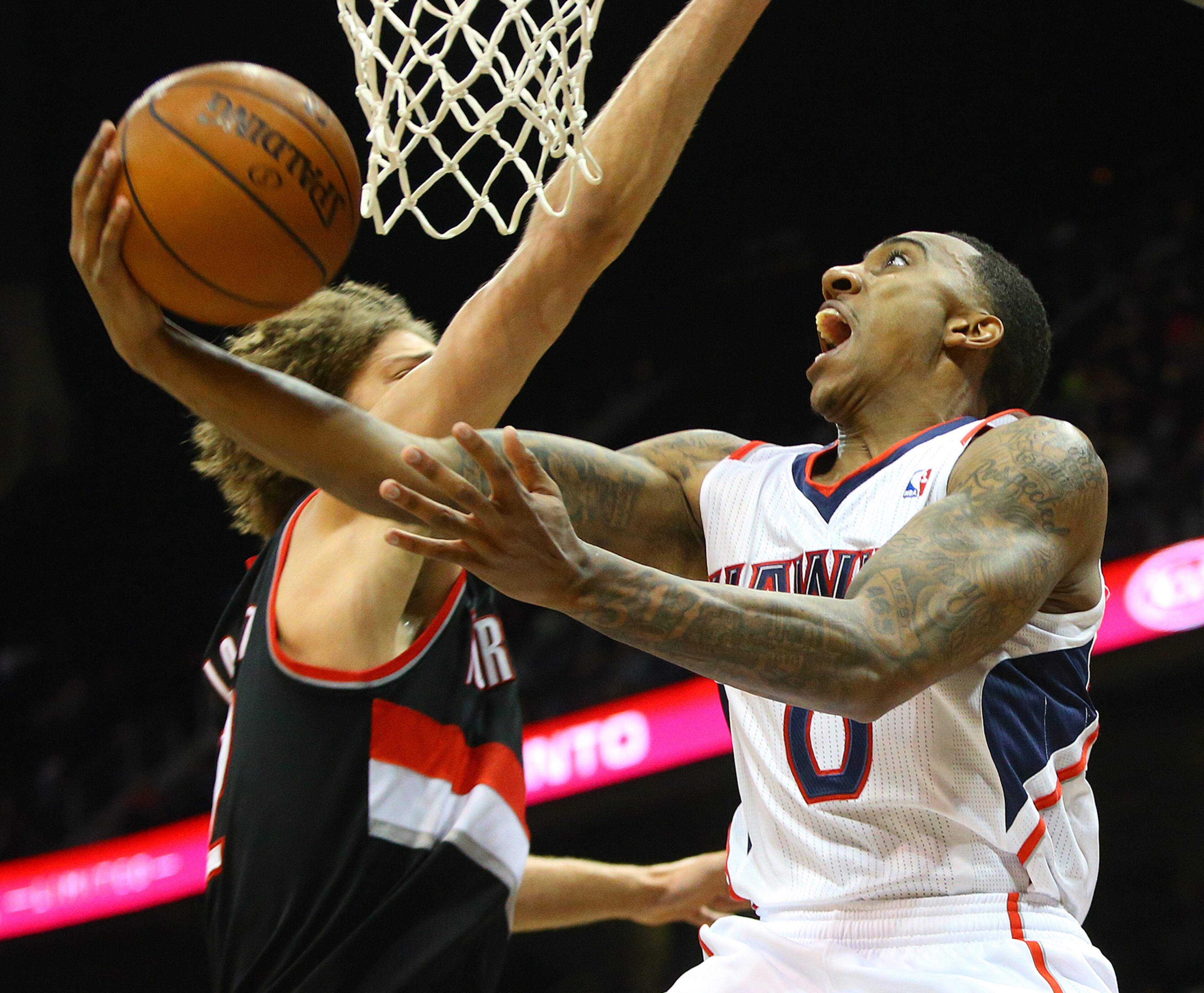 Atlanta Hawks guard Jeff Teague takes it to the basket against Trail Blazers defender center Robin Lopez during the first half of an NBA basketball game on Thursday, March 27, 2014, in Atlanta. CURTIS COMPTON / CCOMPTON@AJC.COM