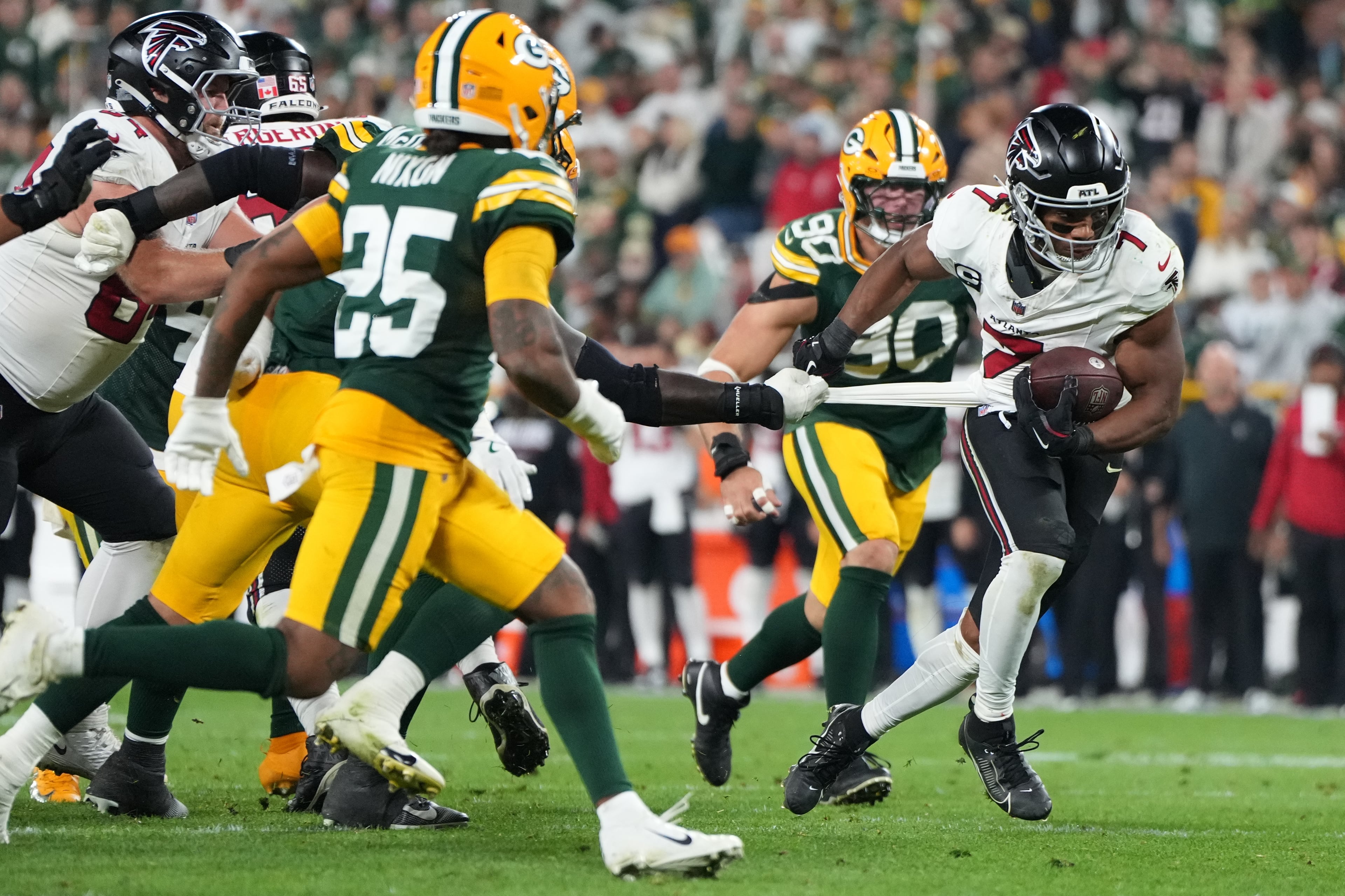 Falcons running back Bijan Robinson (right) makes his way around the Packers’ defense on Thursday, Sept. 24, 2026, at Lambeau Field in Green Bay, Wis. (Abbie Parr/AP)