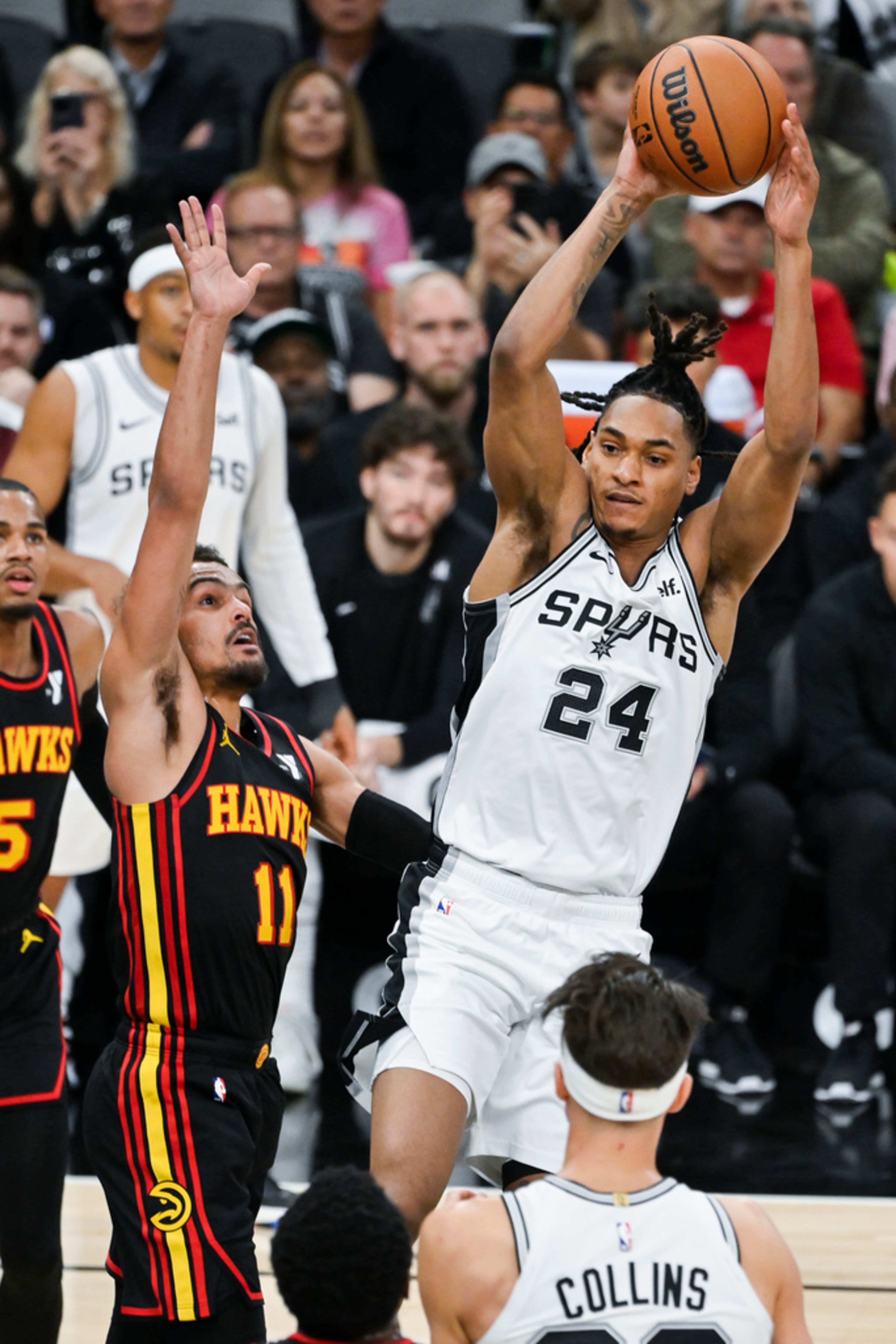 San Antonio Spurs' Devin Vassell (24) looks to pass as he is defended by Atlanta Hawks' Trae Young (11) during the first half of an NBA basketball game Thursday, Nov. 30, 2023, in San Antonio. (AP Photo/Darren Abate)