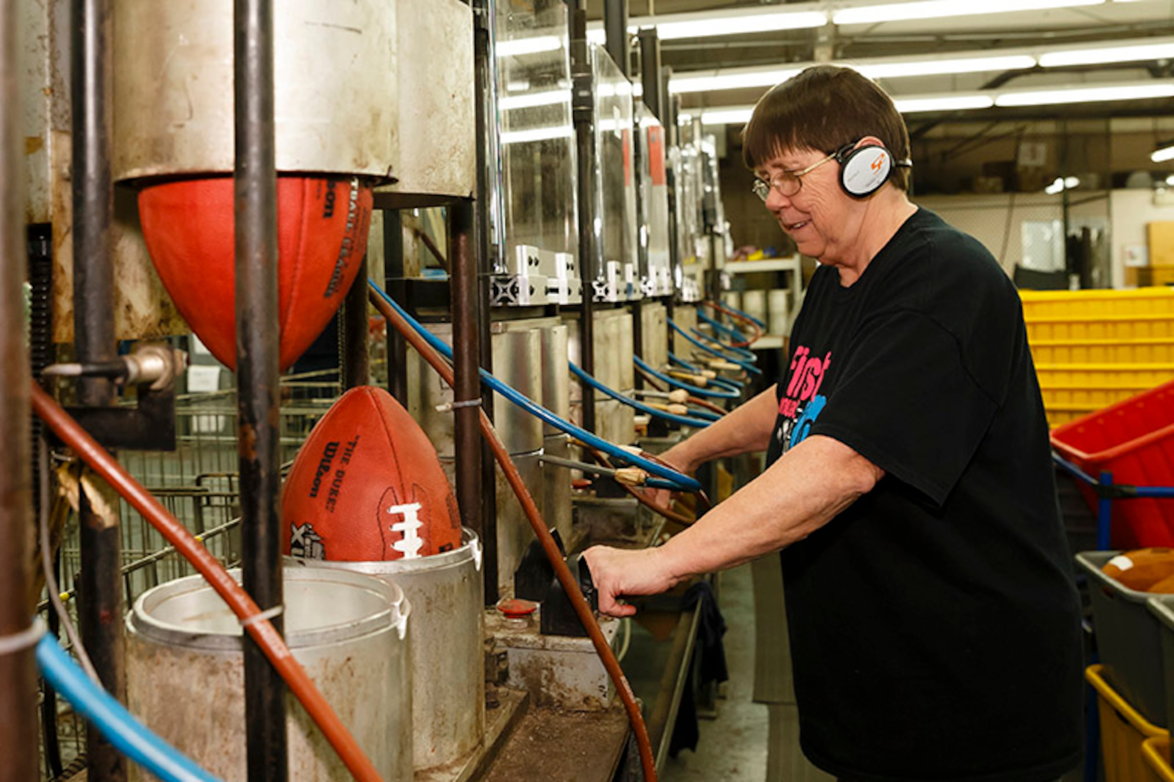 With the help of heavy duty equipment, Deb Connelly molds official game balls for Super Bowl XLVIII.