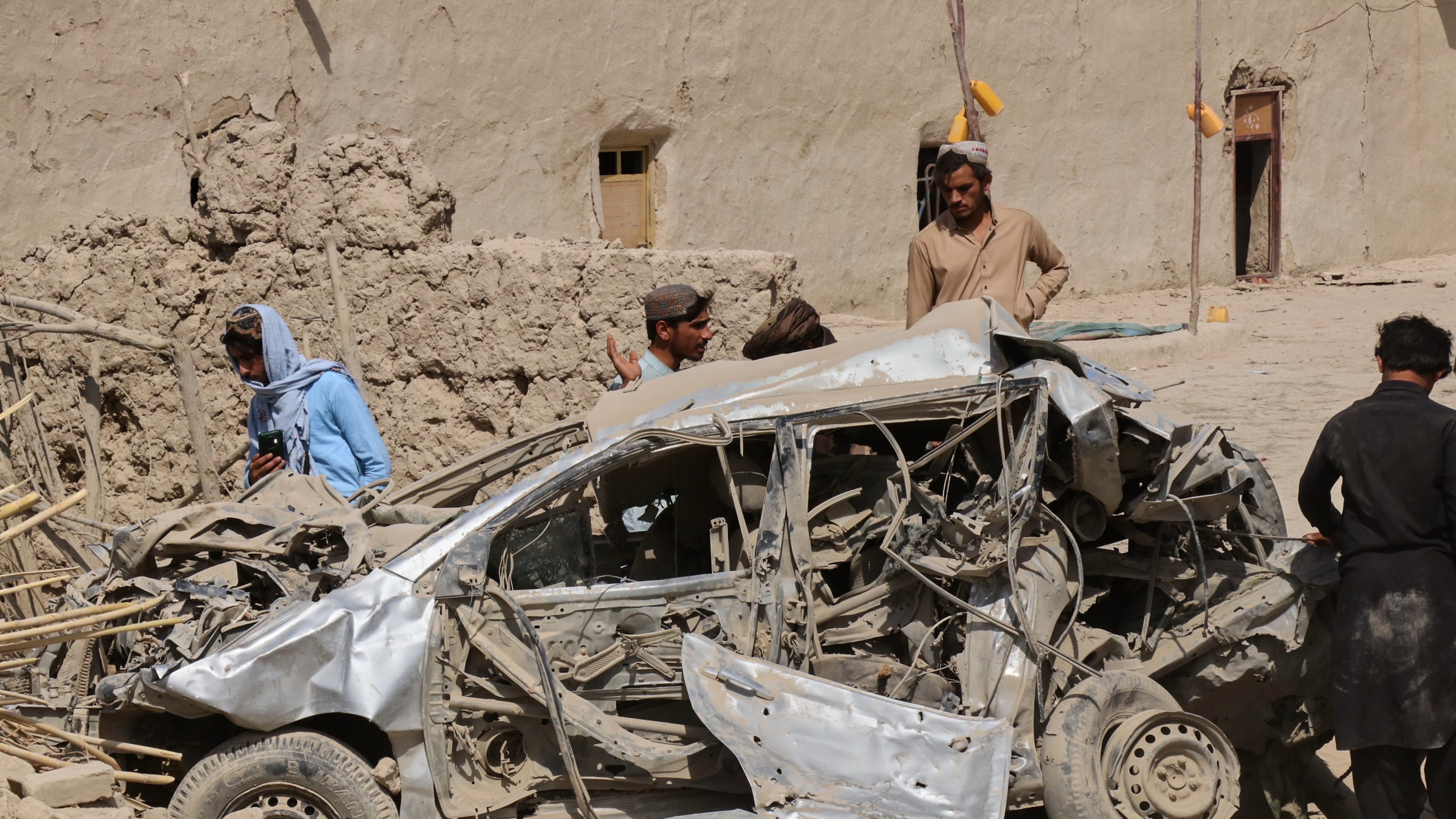Afghan men inspect the wreckage of a vehicle at the site of what Afghanistan's Taliban government said was an overnight Pakistani airstrike in Helmand province, southwestern Afghanistan, Thursday, Oct. 1, 2026. (AP Photo/Abdul Khaliq)
