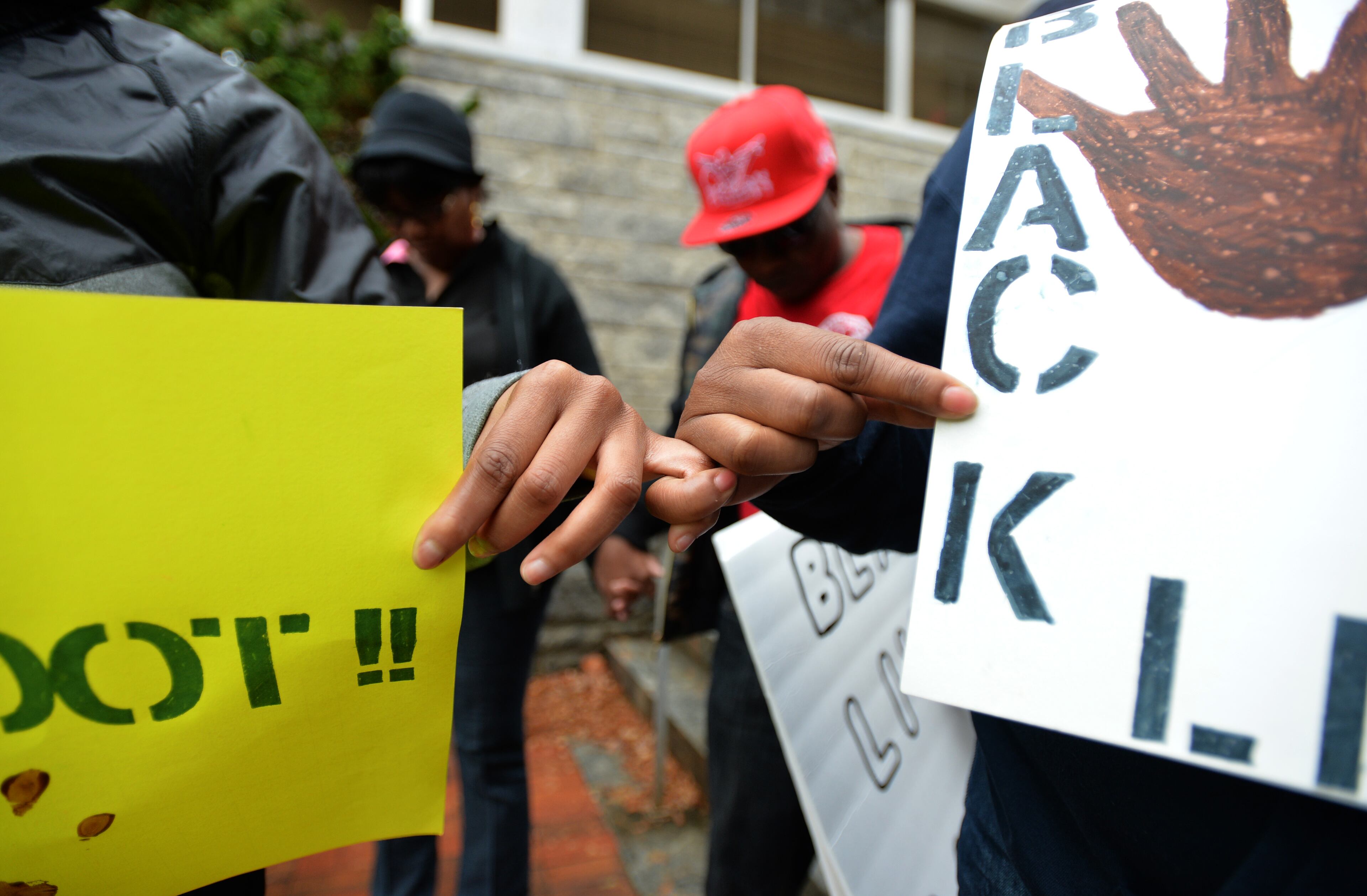 December 6, 2014 Marietta - Protesters link their fingers together outside Marietta Municipal Court during their peaceful demonstration against decisions not to indict white police officers in the deaths of unarmed black men in Ferguson, Mo., and in New York City on Saturday, December 6, 2014. HYOSUB SHIN / HSHIN@AJC.COM