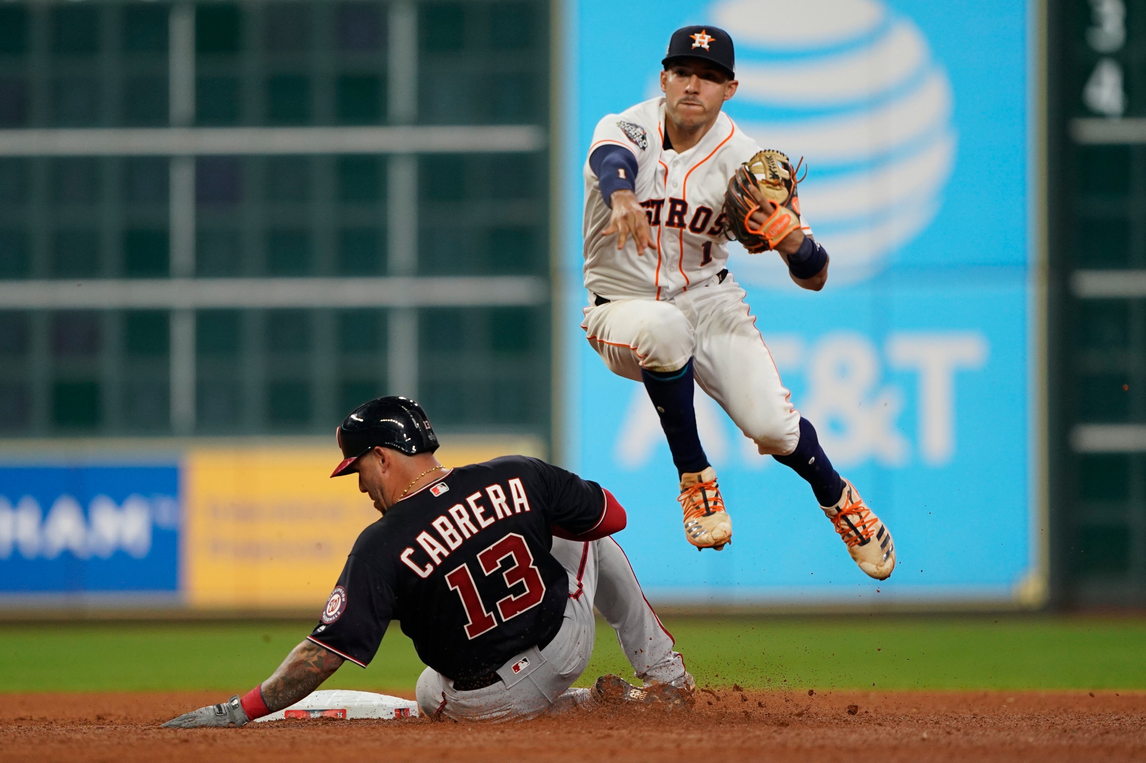 Washington Nationals' Asdrubal Cabrera is out at second as Houston Astros' Carlos Correa turns a double play on a ball hit by Ryan Zimmerman during the sixth inning of Game 1 of the baseball World Series Tuesday, Oct. 22, 2019, in Houston. (AP Photo/David J. Phillip)