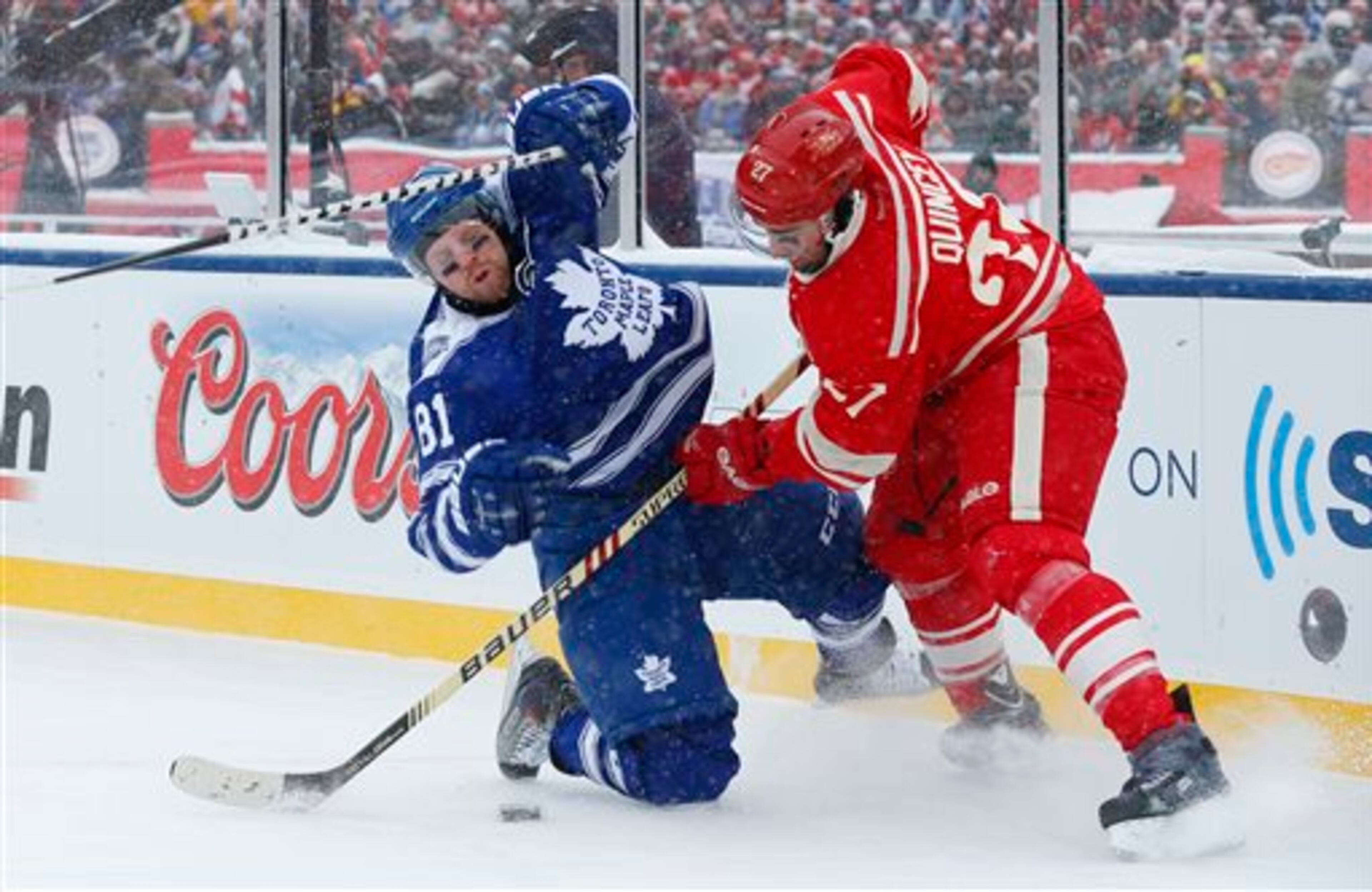 Detroit Red Wings defenseman Kyle Quincey (27) checks Toronto Maple Leafs right wing Phil Kessel (81) during the first period of the Winter Classic outdoor NHL hockey game at Michigan Stadium in Ann Arbor, Mich., Wednesday, Jan. 1, 2014. (AP Photo/Paul Sancya)
