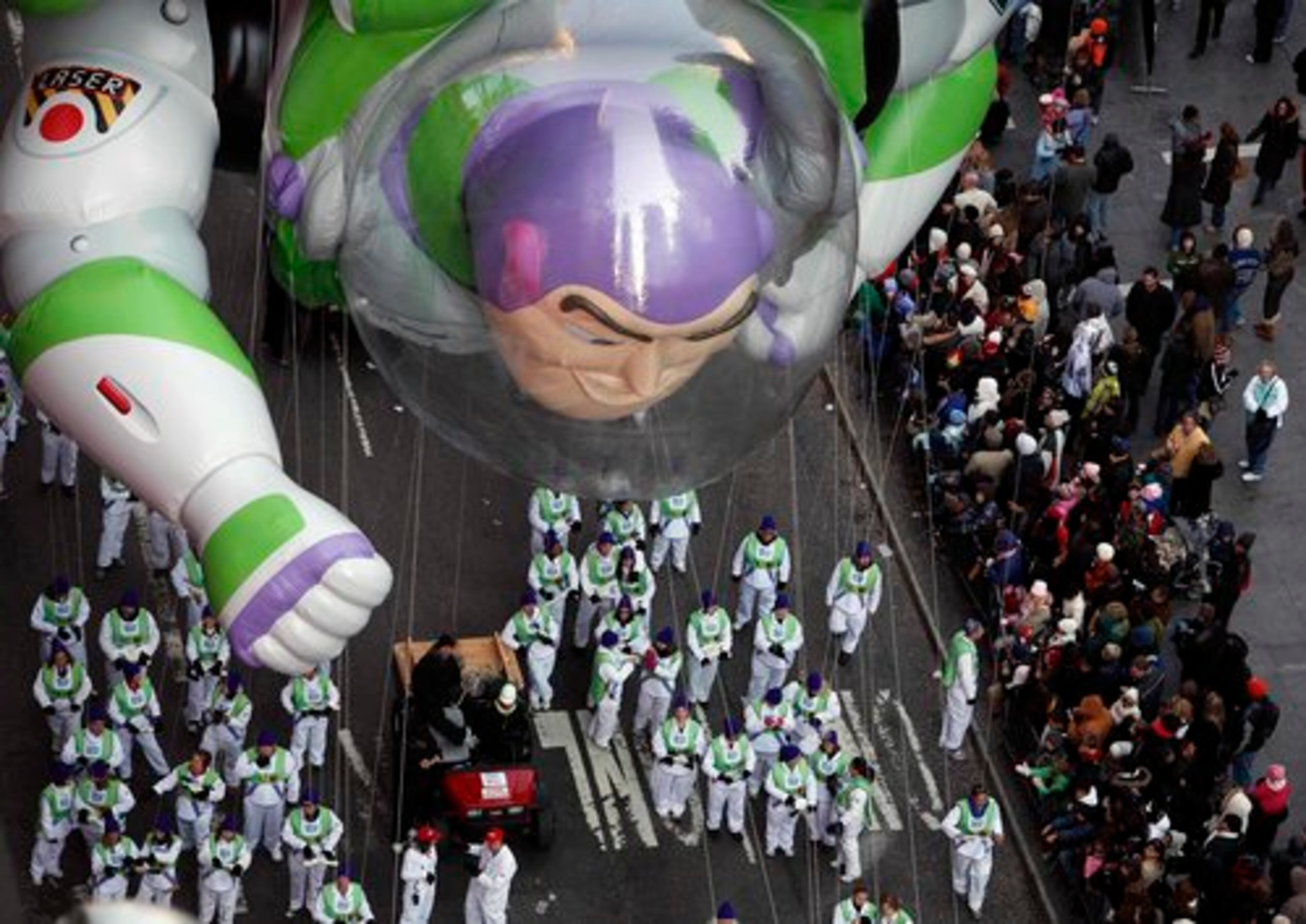 Buzz Lightyear looks more like a spectator than a float hovering above the parade.
