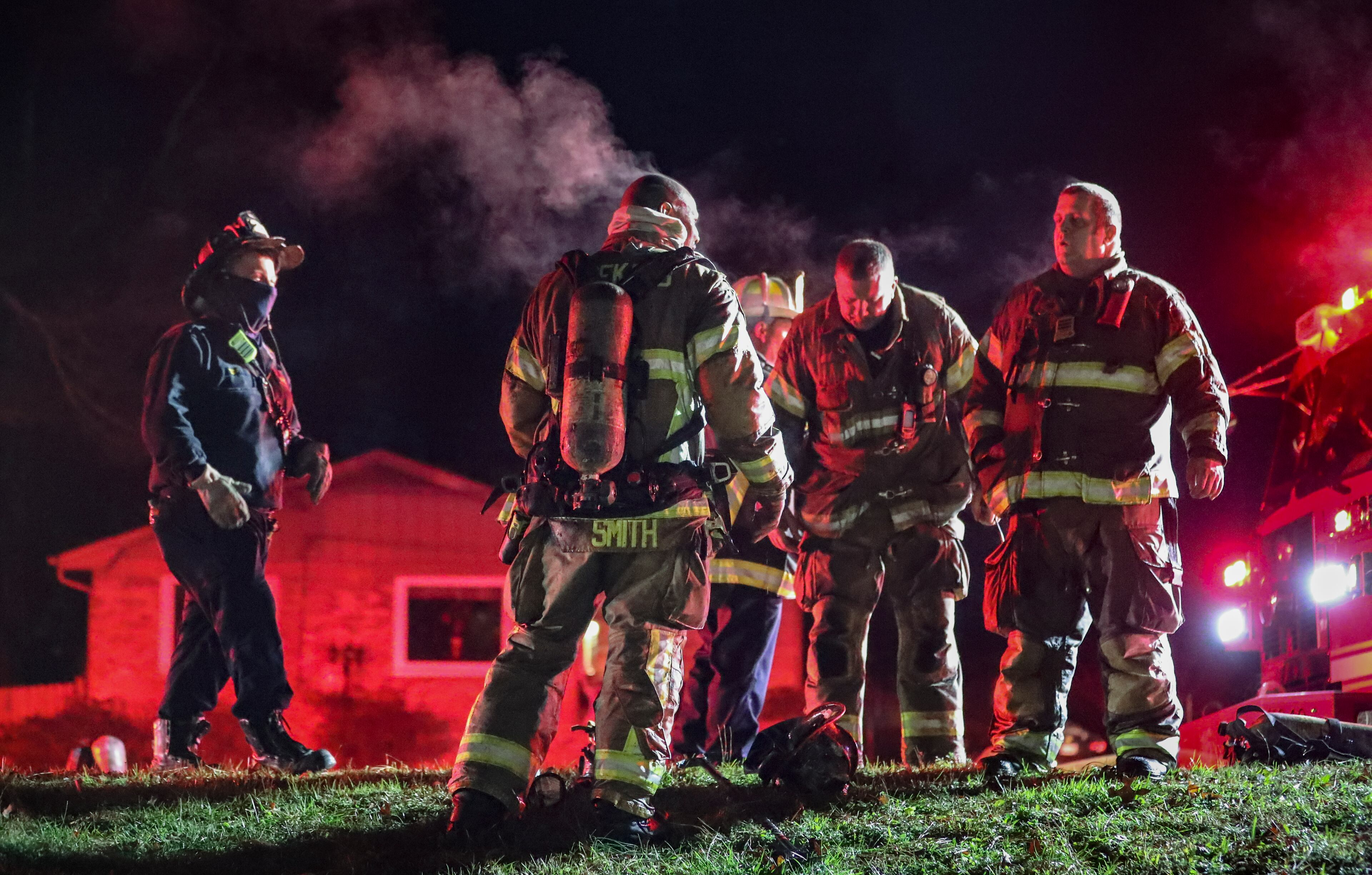 DeKalb County: Fire Capt. Winfred Smith (center-left) emits steam from his overheated body after he came out of a house fire into the morning cold. (John Spink / John.Spink@ajc.com)