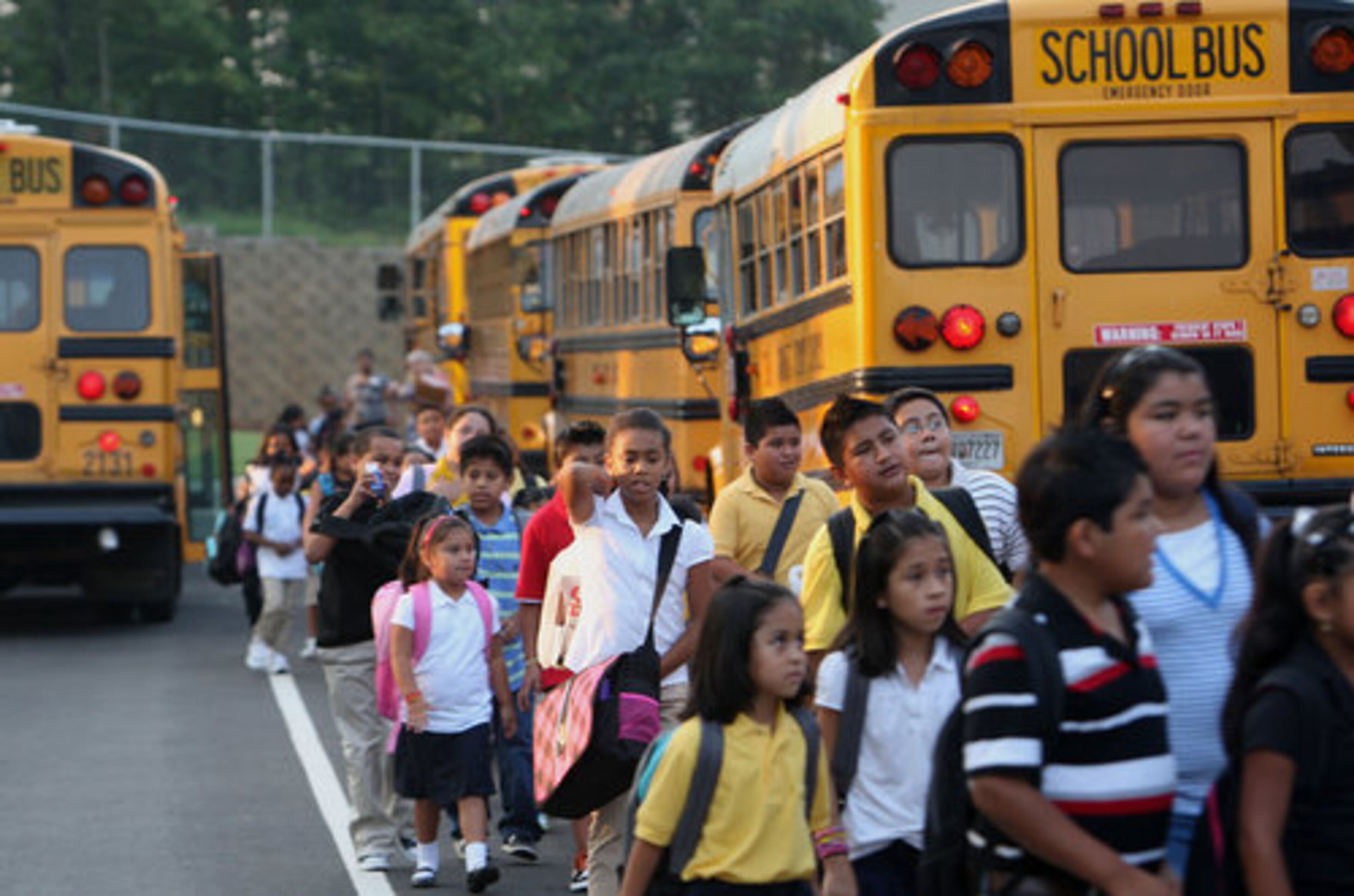 Gwinnett County schoolchildren head from the bus to class. The county said it got 100,000 applicants for 240 open teaching positions for the new school year.
