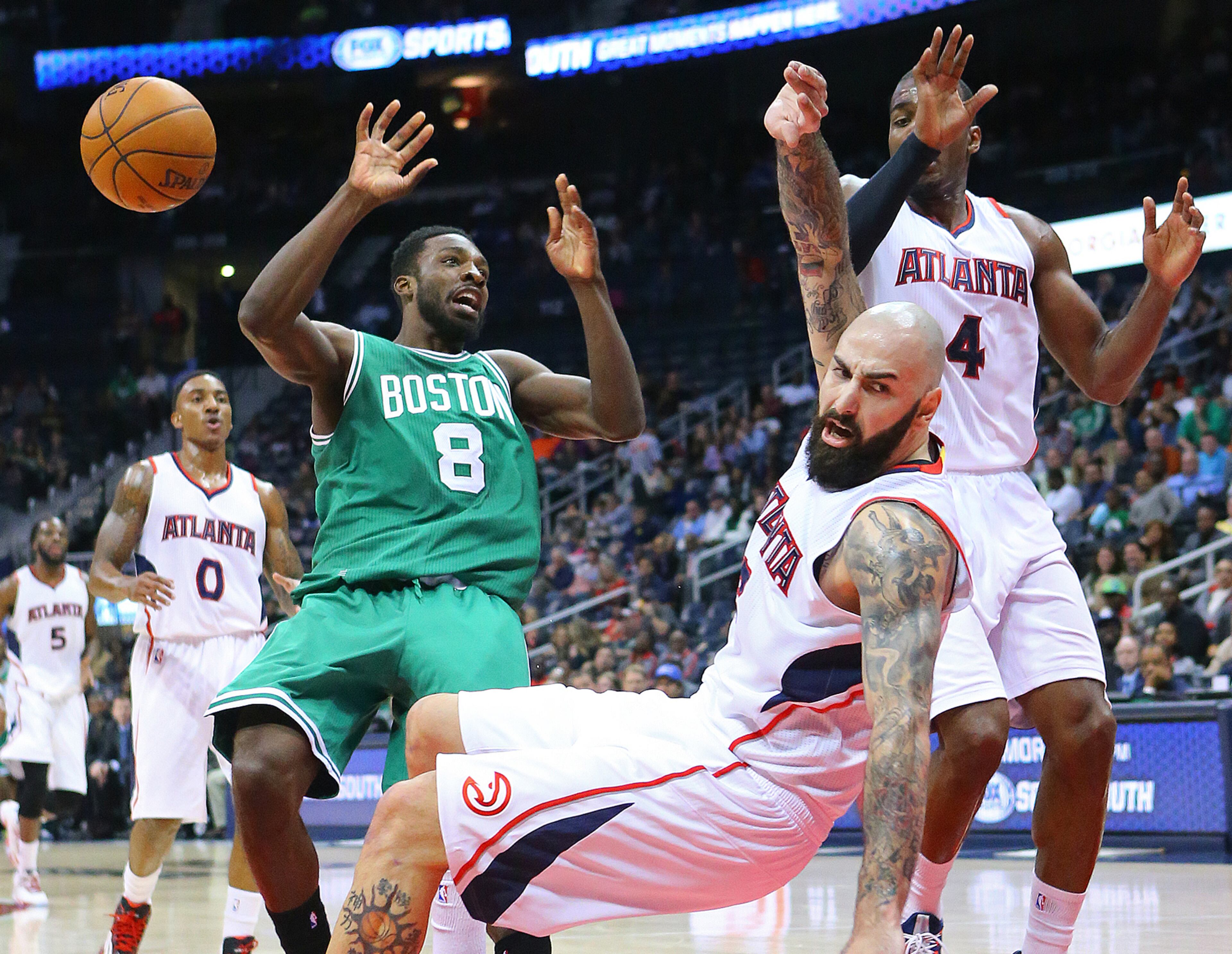 Celtics forward Jeff Green knocks Hawks forward Pero Antic to the hardwood on a collision while trying to drive to the basket during the first half in an NBA basketball game on Tuesday, Dec. 2, 2014, in Atlanta. CURTIS COMPTON / CCOMPTON@AJC.COM
