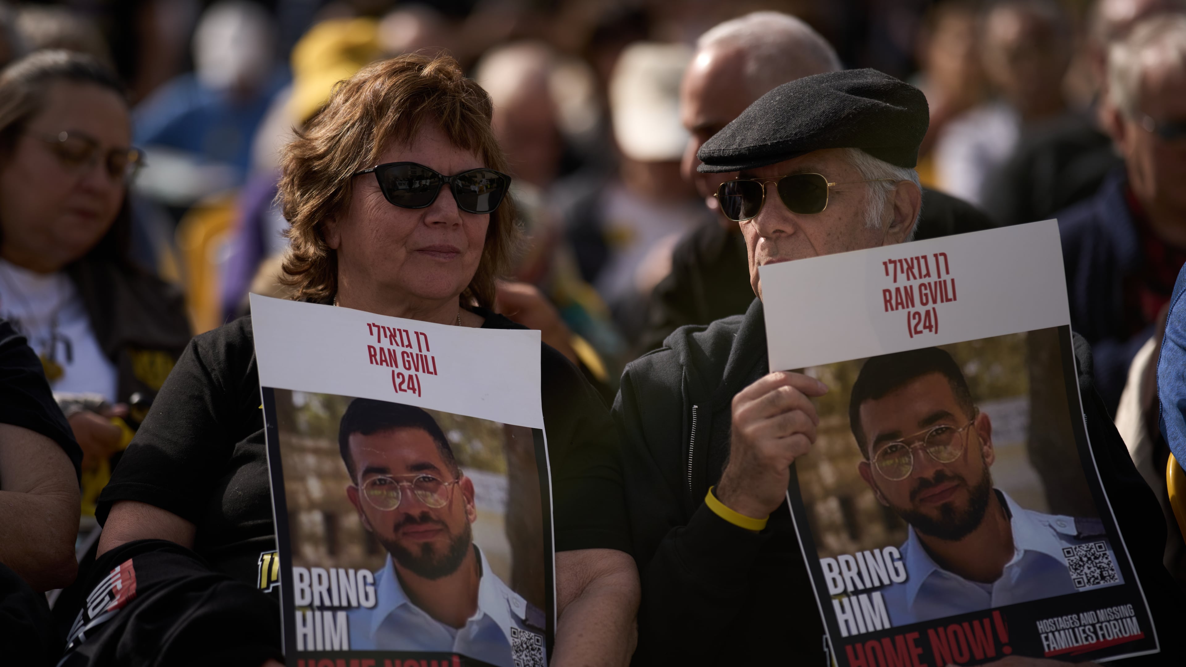 People hold signs with a photo of Ran Gvili, who was killed while fighting Hamas militants during the Oct. 7, 2023 attack and whose body has been held in Gaza ever since, during a rally calling for his return in Tel Aviv, Israel, Friday, Jan. 23, 2026. (AP Photo/Leo Correa)