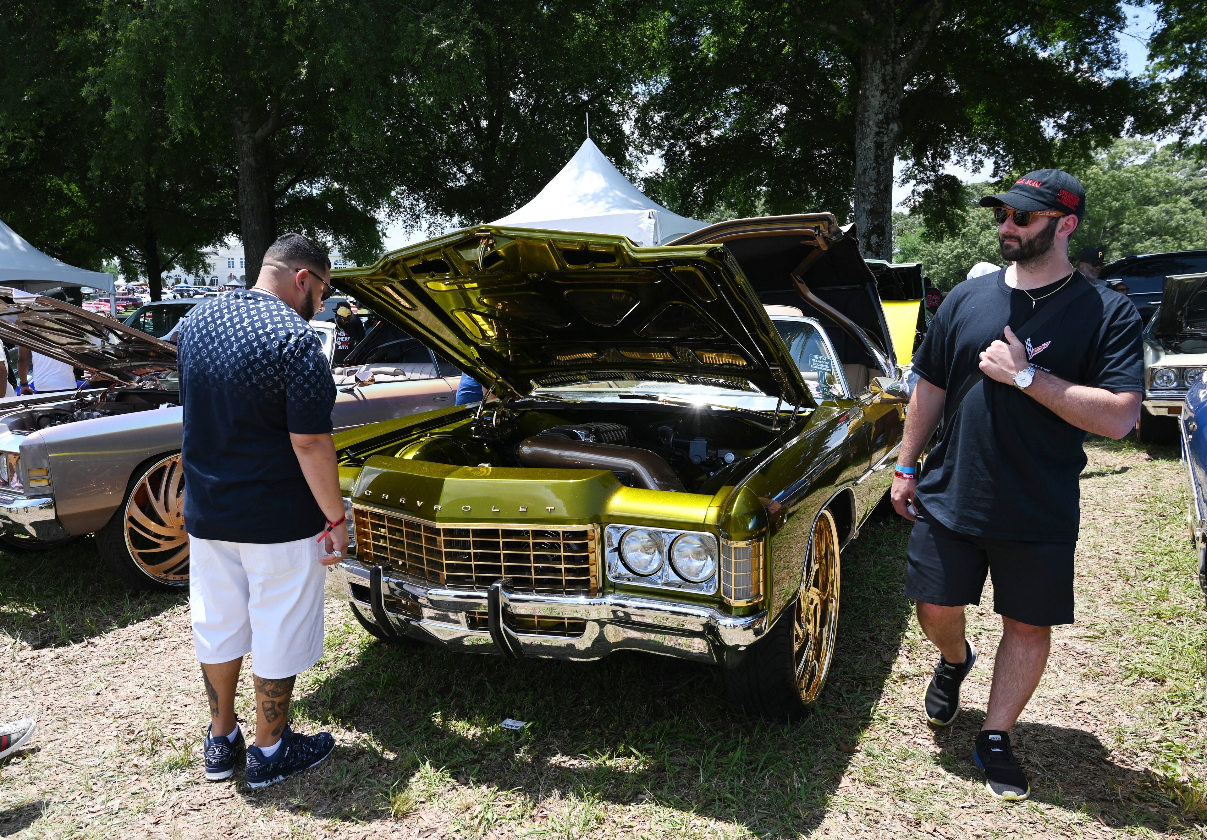 Attendees walk through some of classic/custom and luxury vehicles on Rick Ross’s property during the 4th Annual Rick Ross Car and Bike Show, Saturday, June 7, 2025, in Fayetteville. The 4th Annual Rick Ross Car and Bike Show will include a vendor market with more than 30 vendors, food trucks, fleets of classic/custom automobiles, luxury vehicles, boats, RVs and trailers on the front of the mansion. Stage performances include Plies, Ross' new signee Nino Breeze and Ross himself. (Hyosub Shin / AJC)