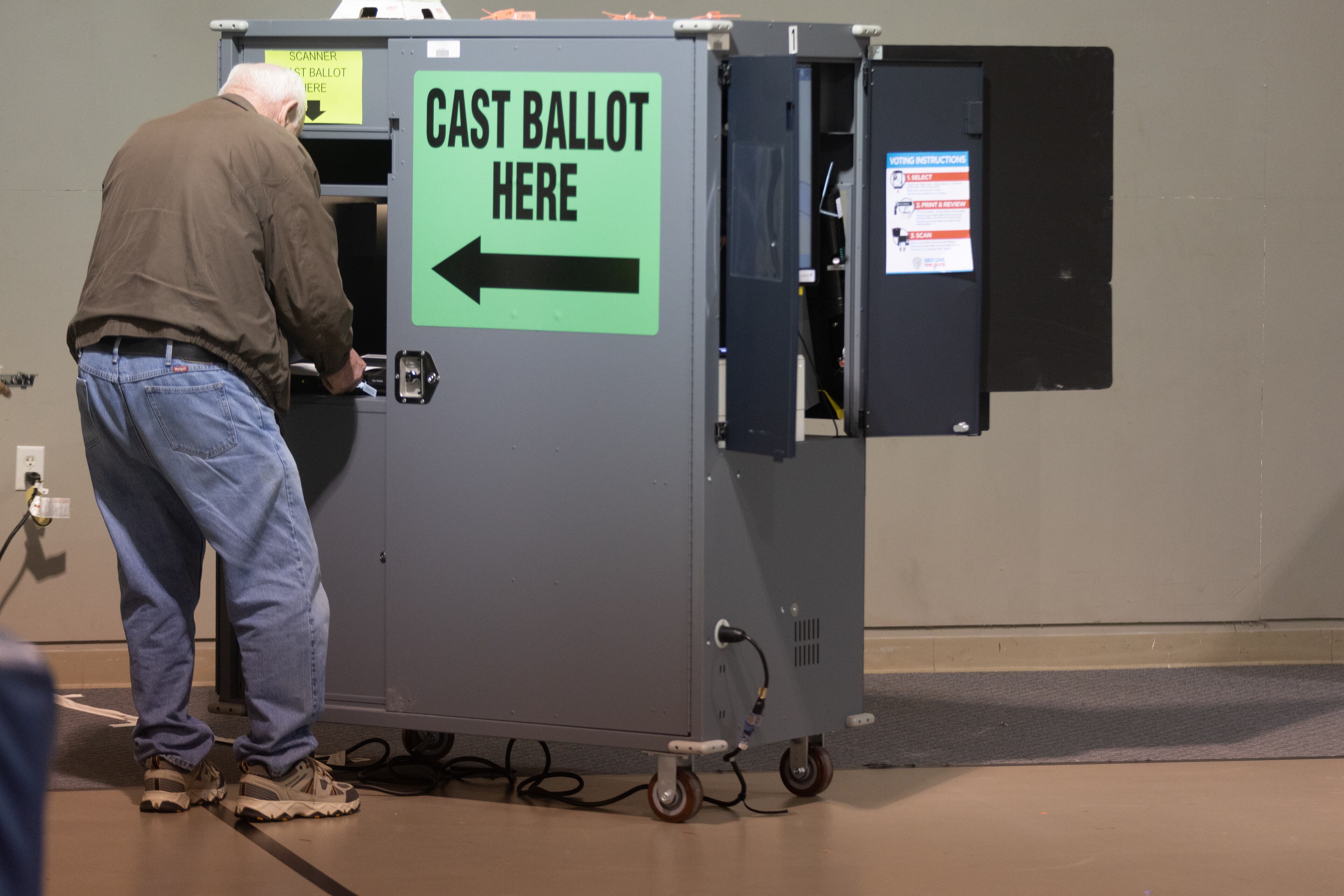 A voter at Calvary Baptist Church in Estelle scans his ballot after voting early Tuesday morning, Dec. 6, 2022. (Steve Schaefer/steve.schaefer@ajc.com)