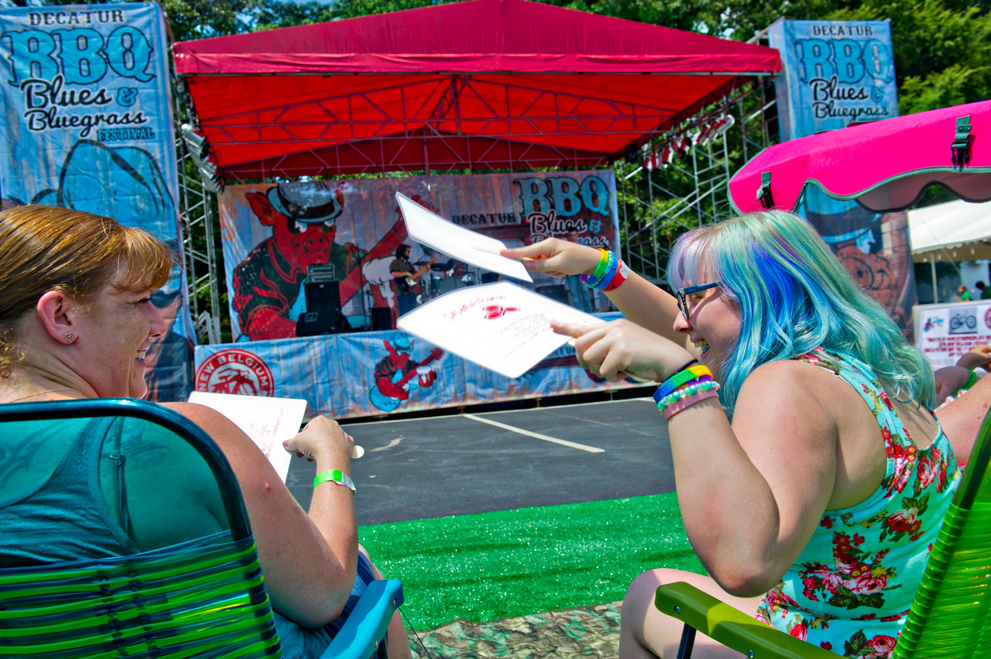 Candice Darling (left) is fanned by her daughter Ayralynn as the listen to The Georgia Flood perform during the Decatur BBQ, Blues & Bluegrass Festival at Harmony Park in Decatur on Saturday, August 16, 2014. The 14th annual festival featured over seven hours of blues and bluegrass performances as well as beer, barbeque and children's activities.