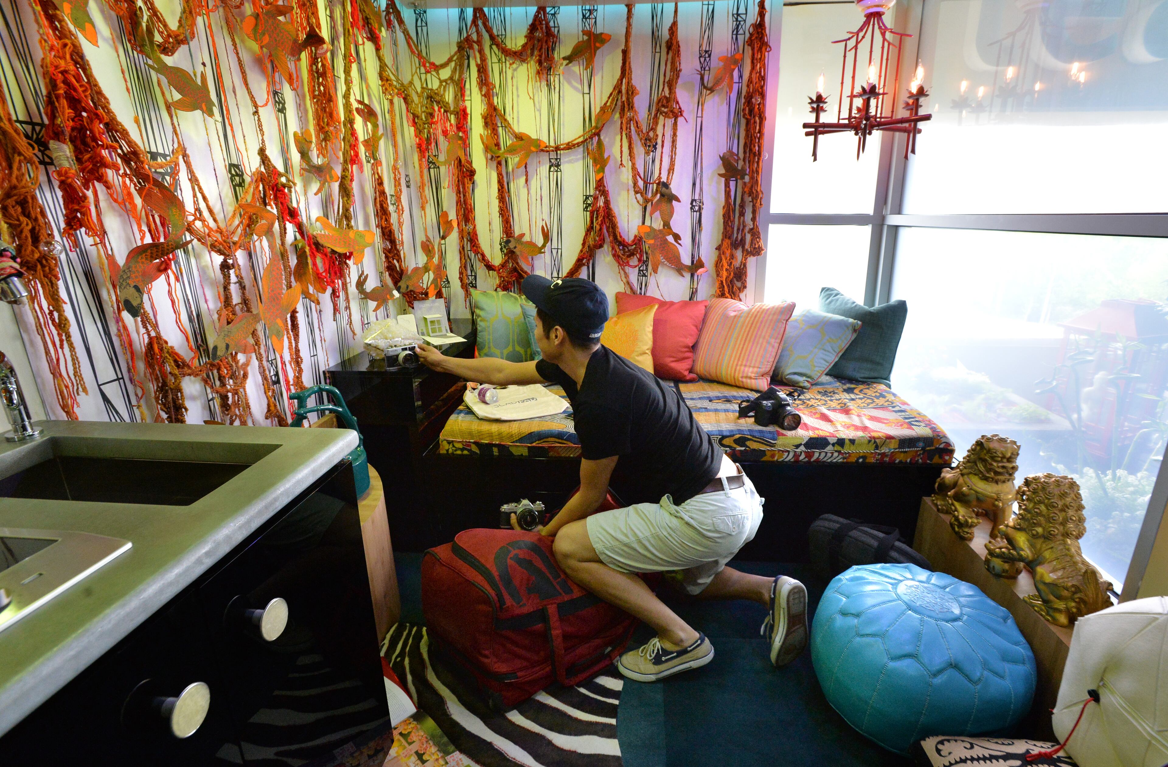 April 15, 2014 Atlanta - Carlos Maldonado, junior photography major, unpacks in SCADpad Asia, one of 135-square-foot SCADpad units, where he will stay next 10 days, on the 4th floor of SCAD Atlanta's parking garage on Tuesday, April 15, 2014. Savannah College of Art and Design (SCAD) unveiled SCADpad, a unique micro-housing and adaptive reuse experiment that transformed the parking structure of its midtown Atlanta location into a sustainable community that proposes an answer to the world� growing urban housing challenges. HYOSUB SHIN / HSHIN@AJC.COM