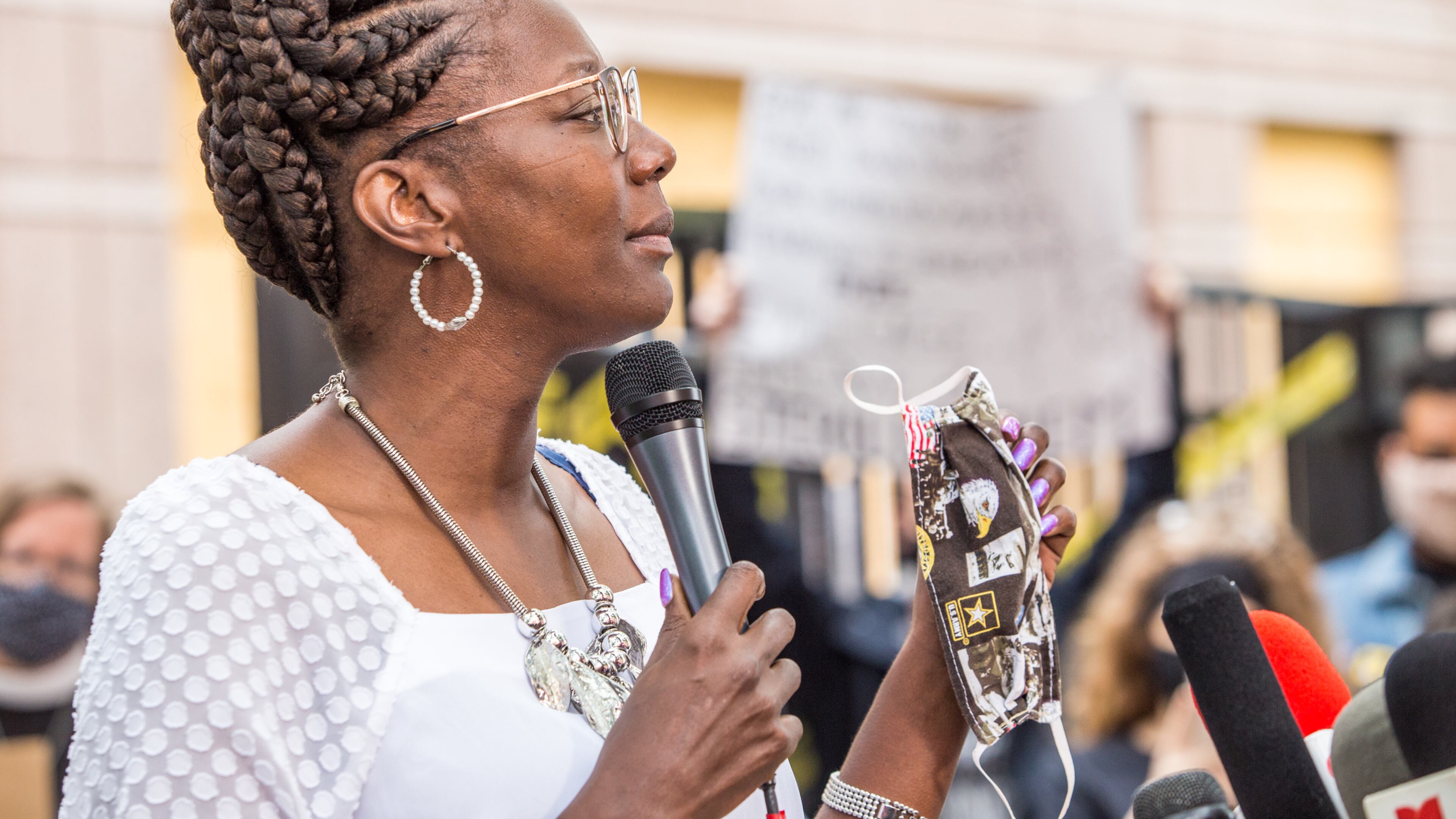 Dawn Wooten, a LPN, who worked in the Irwin County Detention Center in Ocilla, GA on and off for more than 5 years, expresses concerns Tuesday, Sept 15, 2020, about health and safety conditions at the immigration detention center during Covid where PPE are not distributed regularly to nurses, detainees or staff. The mask she is holding was what she purchased after asking for an E95 mask and being denied by her former employer because she was issued a mask three months prior. Wooten and supporters hold a press conference in front of the Atlanta ICE field office. (Jenni Girtman for The Atlanta Journal-Constitution)