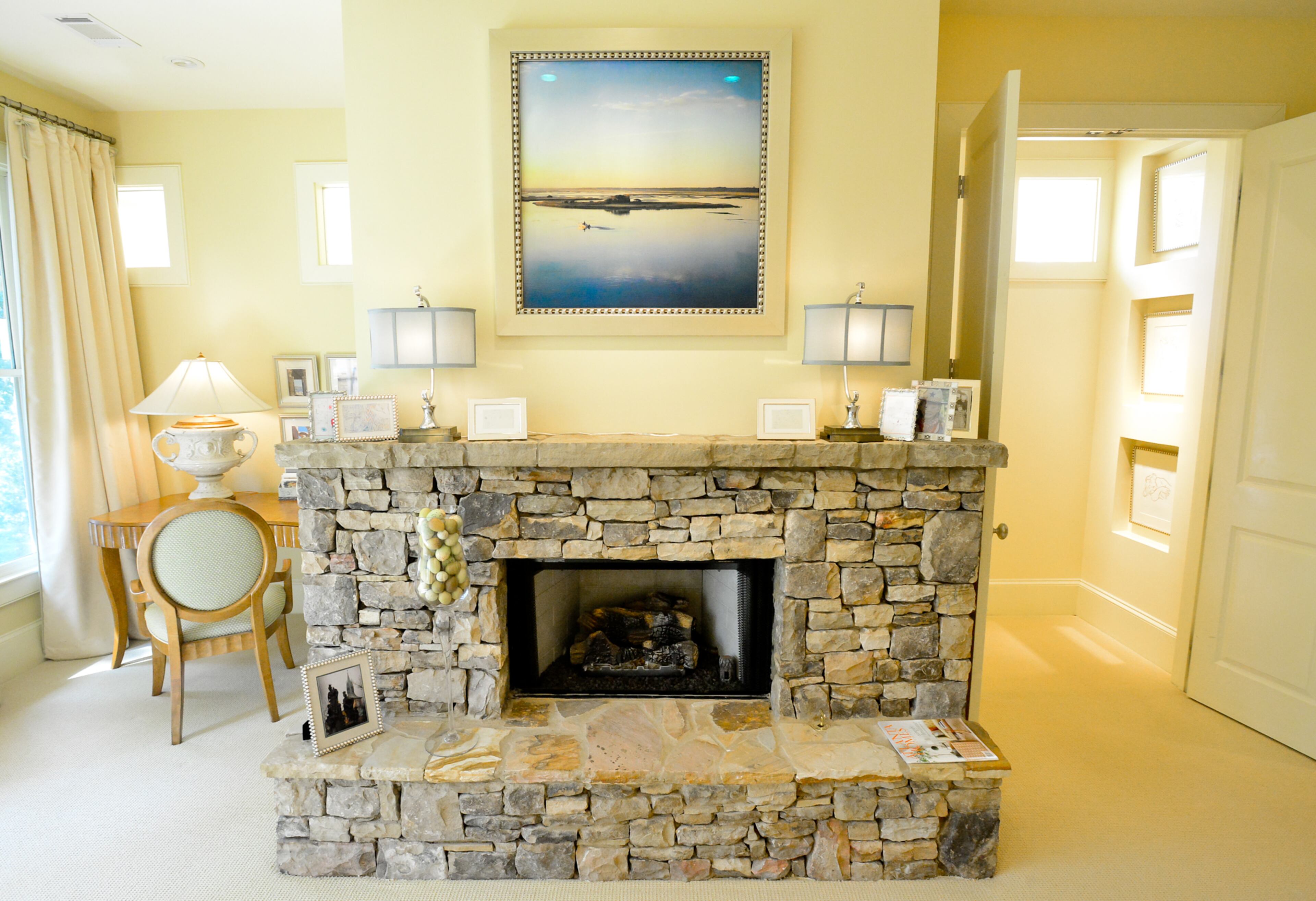 The desk niche features a desk and chair from American Furniture with an over-scaled lamp from The Painted Monkey in Roswell and photographic art from homeowner's Egyptian travels. Favorite interior design feature: Seven stone fireplaces capture the feeling and character of a mountain home. -- Text by Lori Johnston